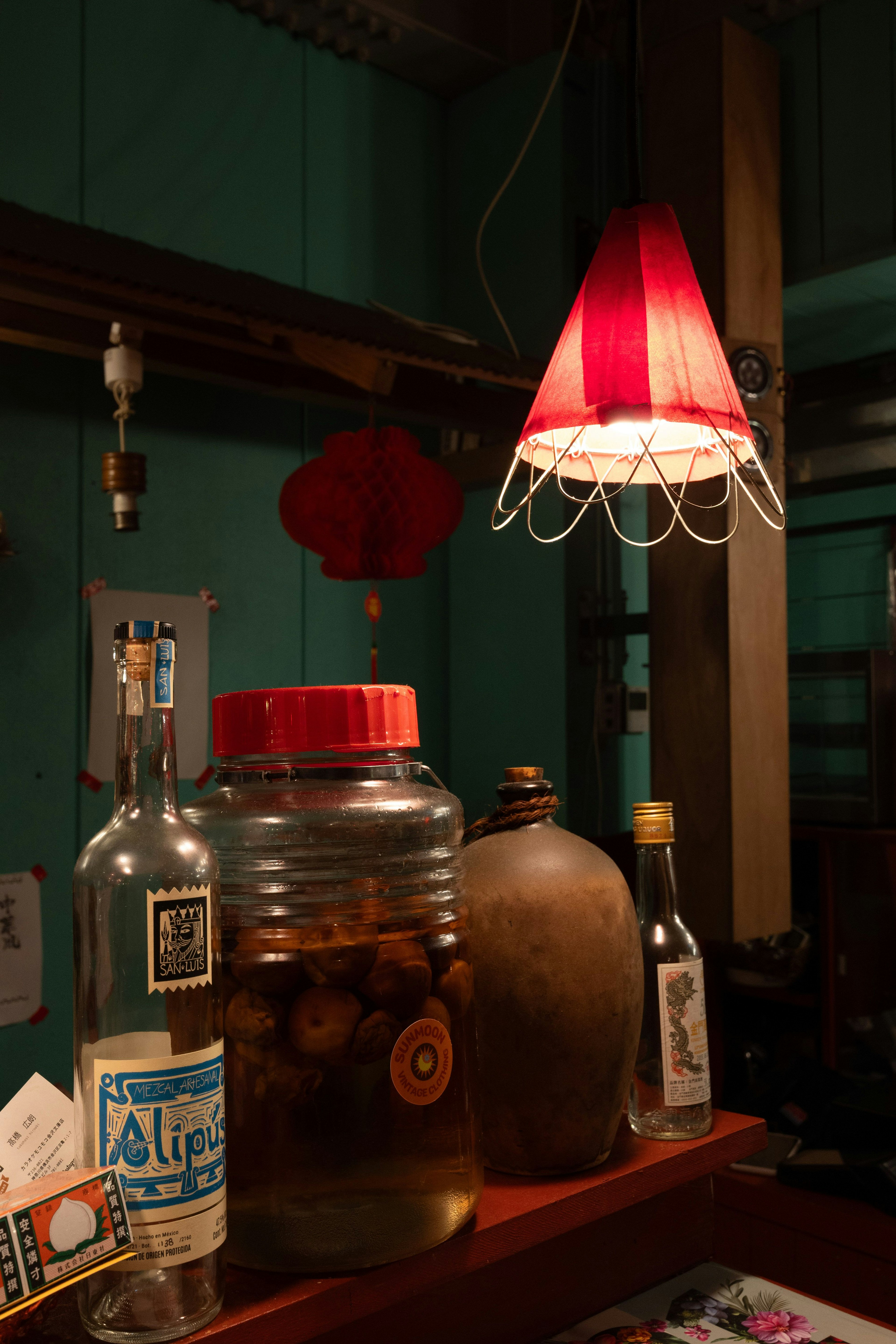 Pemandangan interior meja dengan lampu merah dan berbagai botol