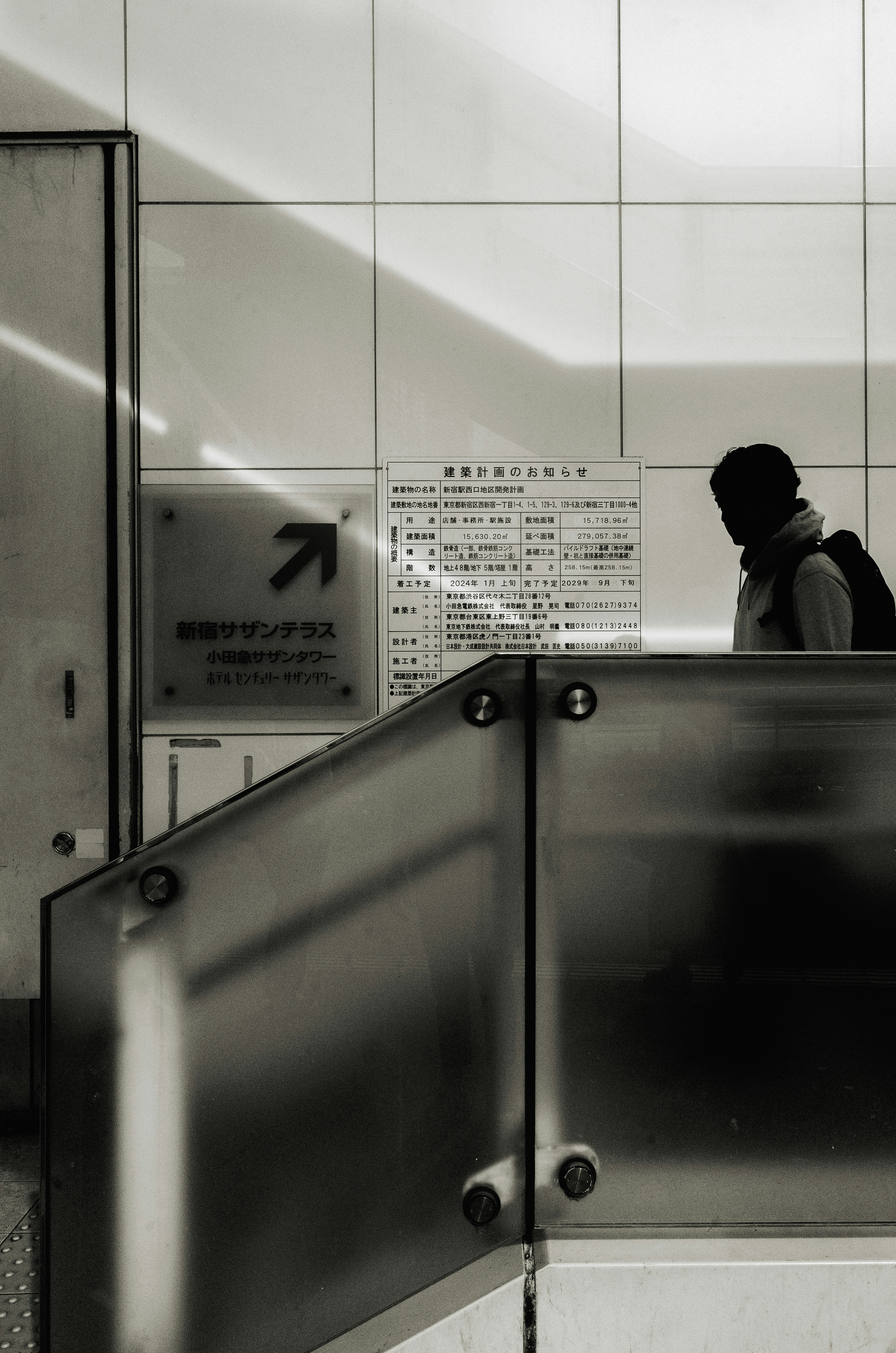 Silhouette of a person ascending a staircase with a directional sign