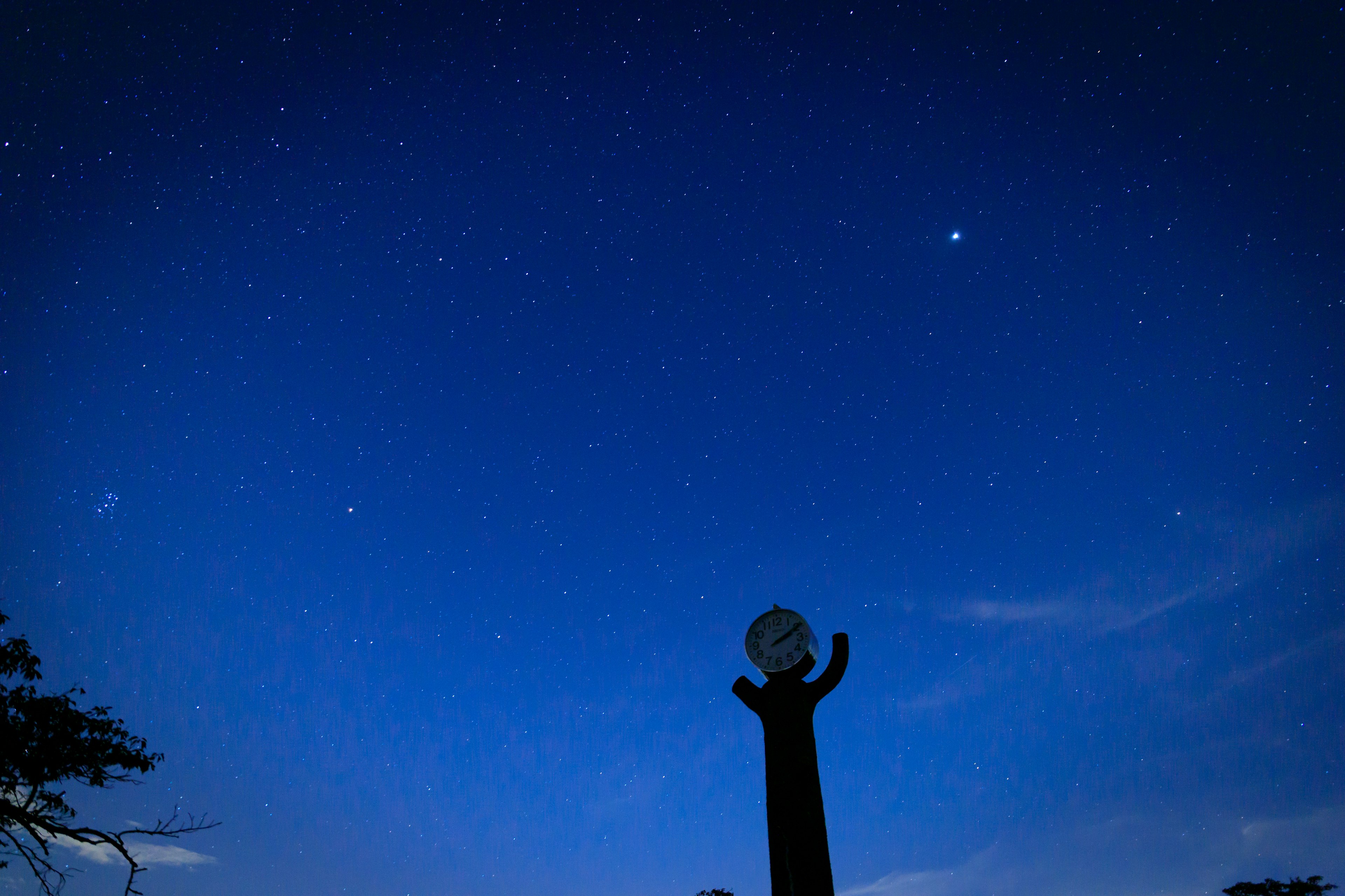 Silueta de una escultura bajo un cielo estrellado