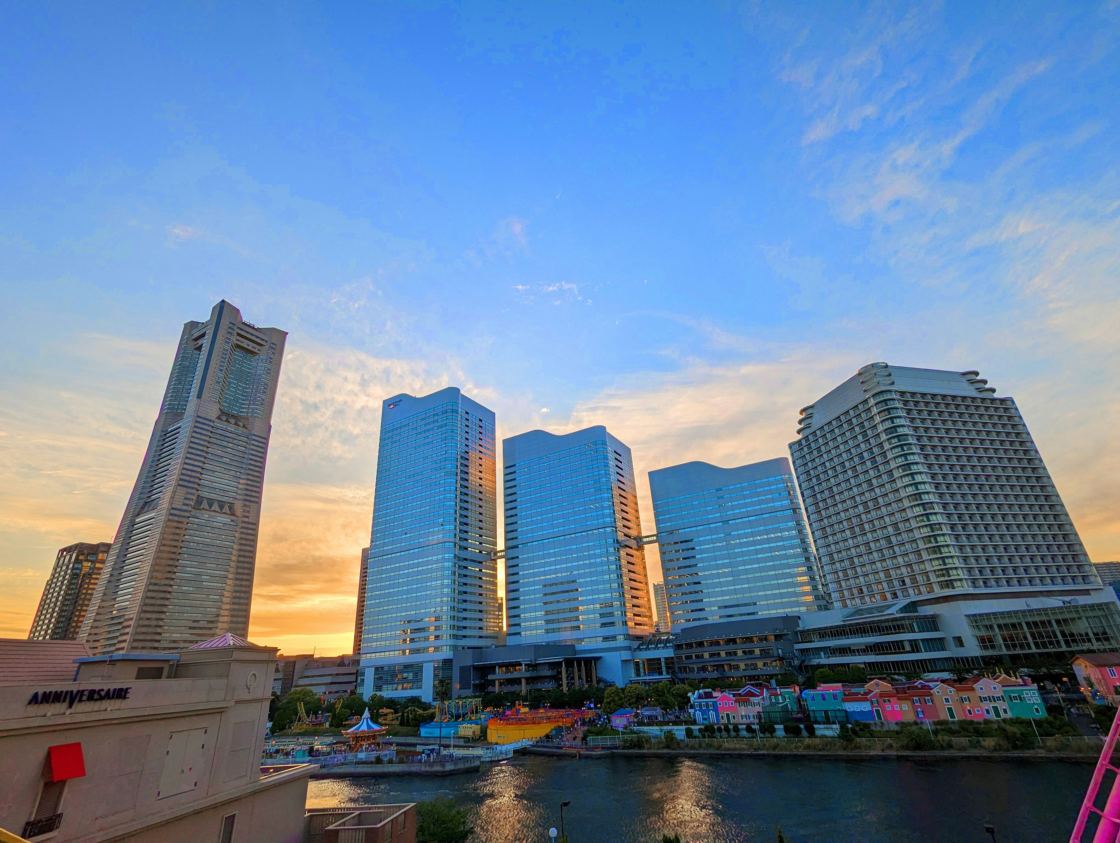 Skyline di grattacieli moderni al tramonto con un fiume in primo piano