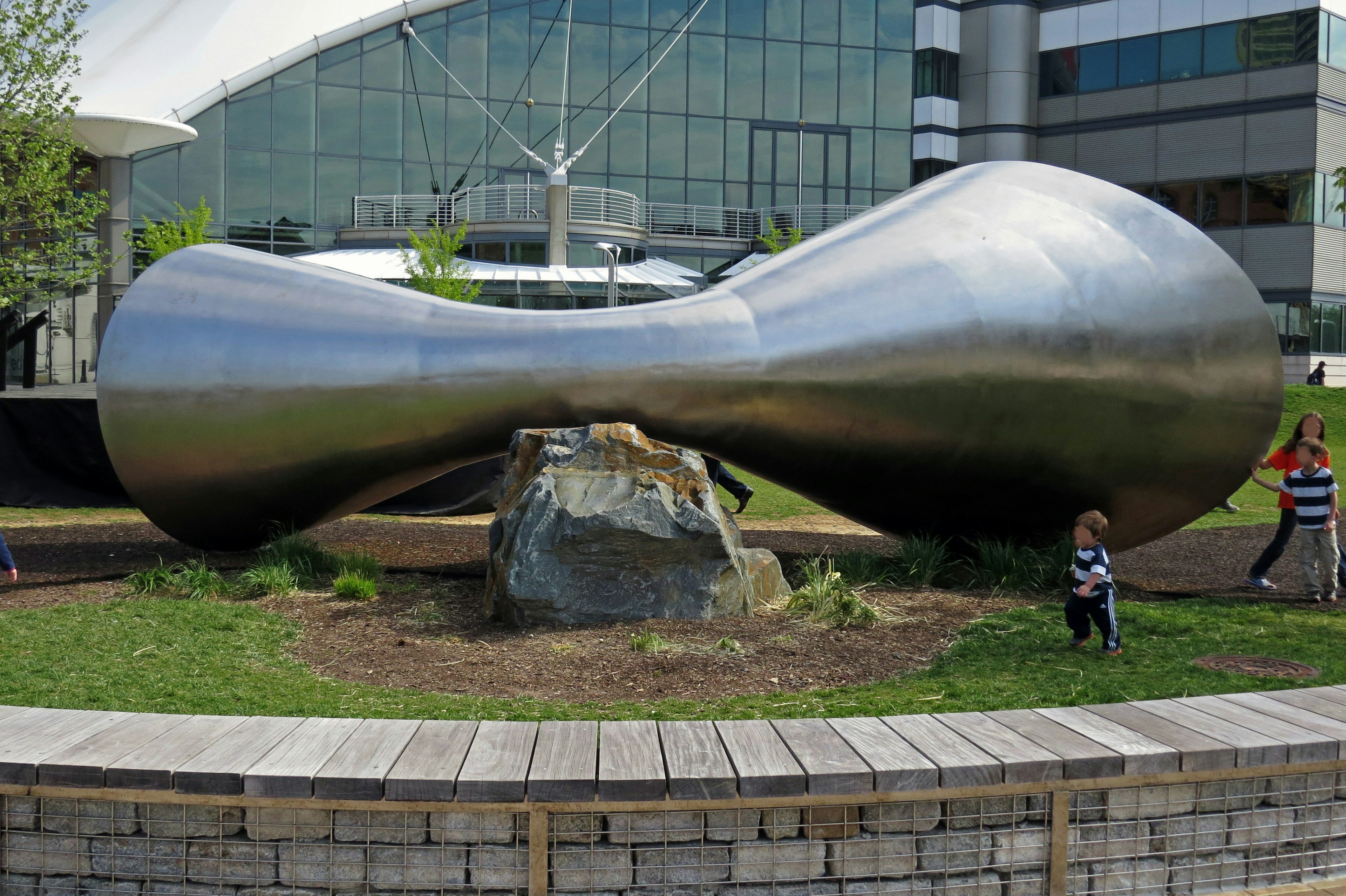 Escultura de metal en un parque con vegetación circundante