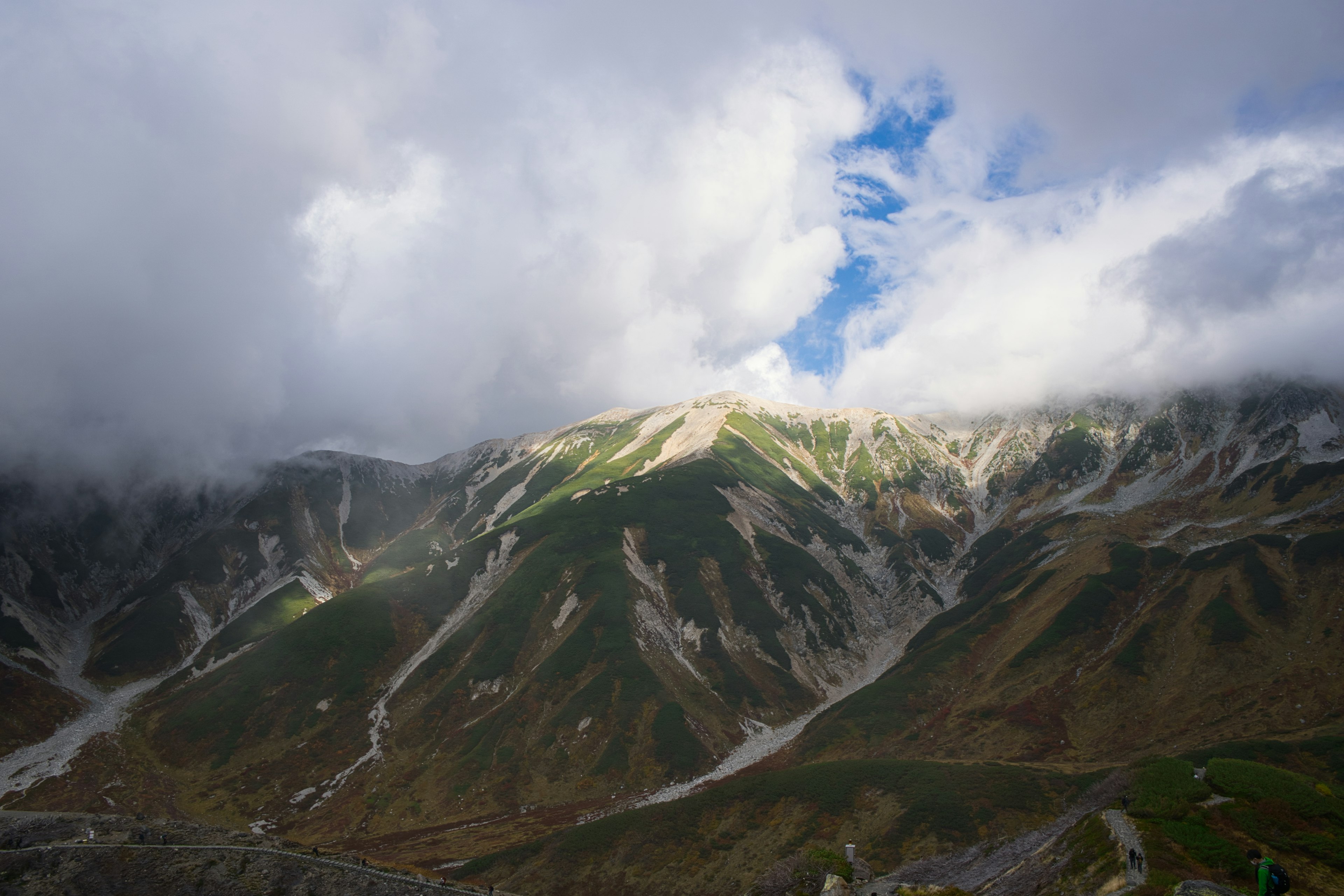 山々に雲がかかり、青空が見える風景