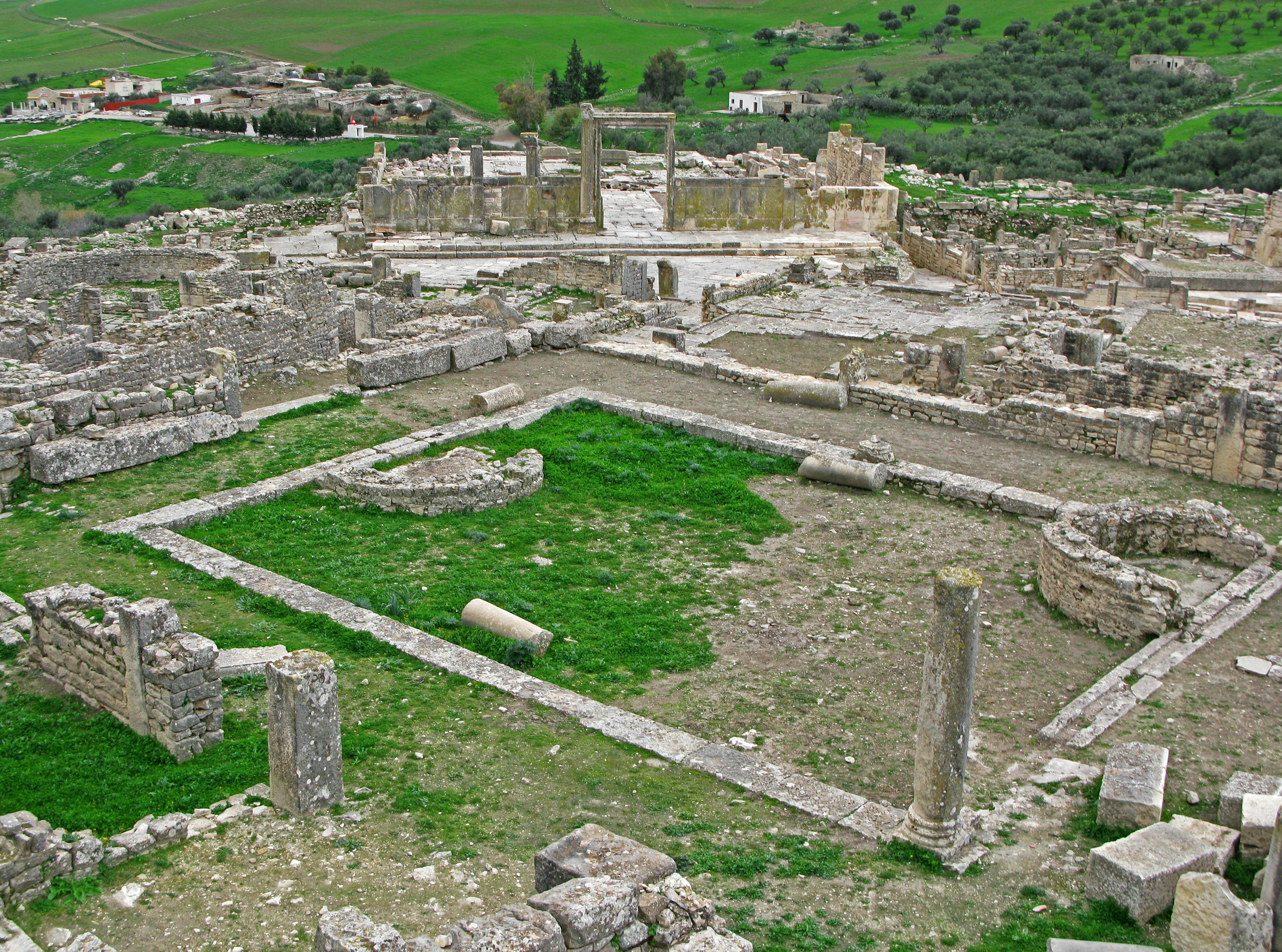 Paesaggio di antiche rovine con aree erbose e strutture in pietra