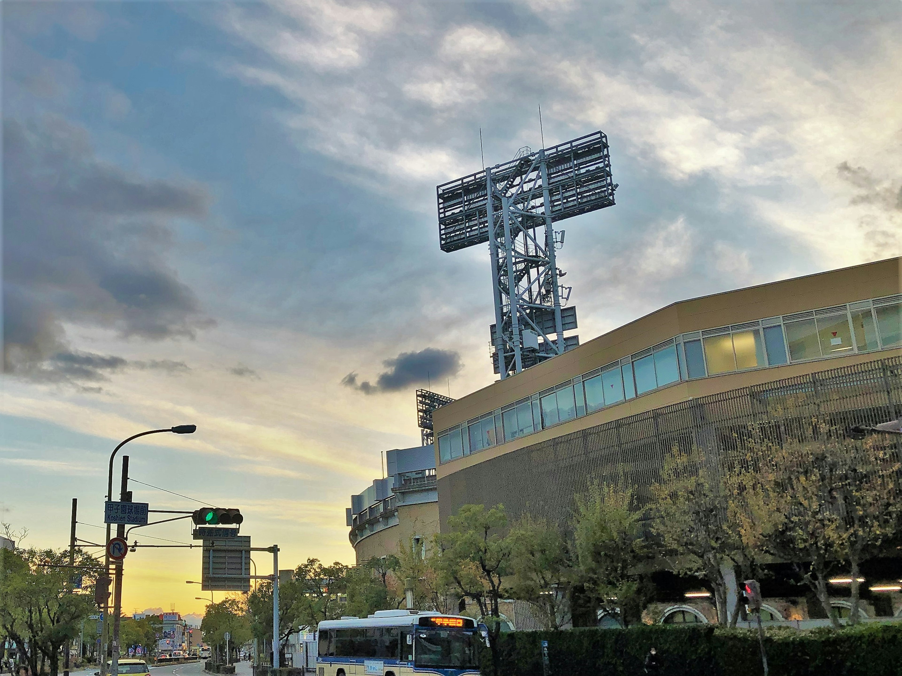 Exterior del estadio con una torre y nubes coloridas en el cielo