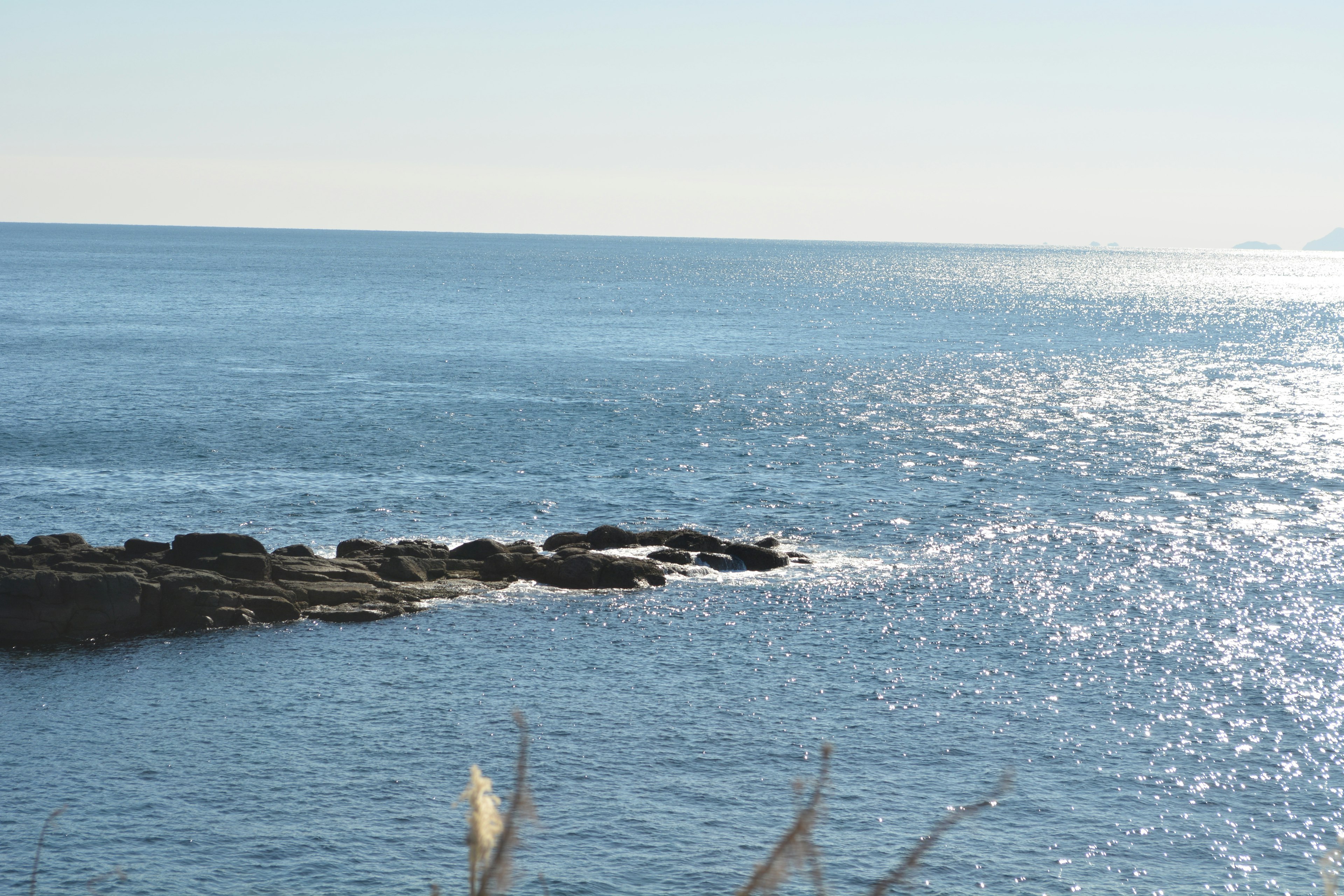 Mare calmo e costa rocciosa sotto un cielo sereno