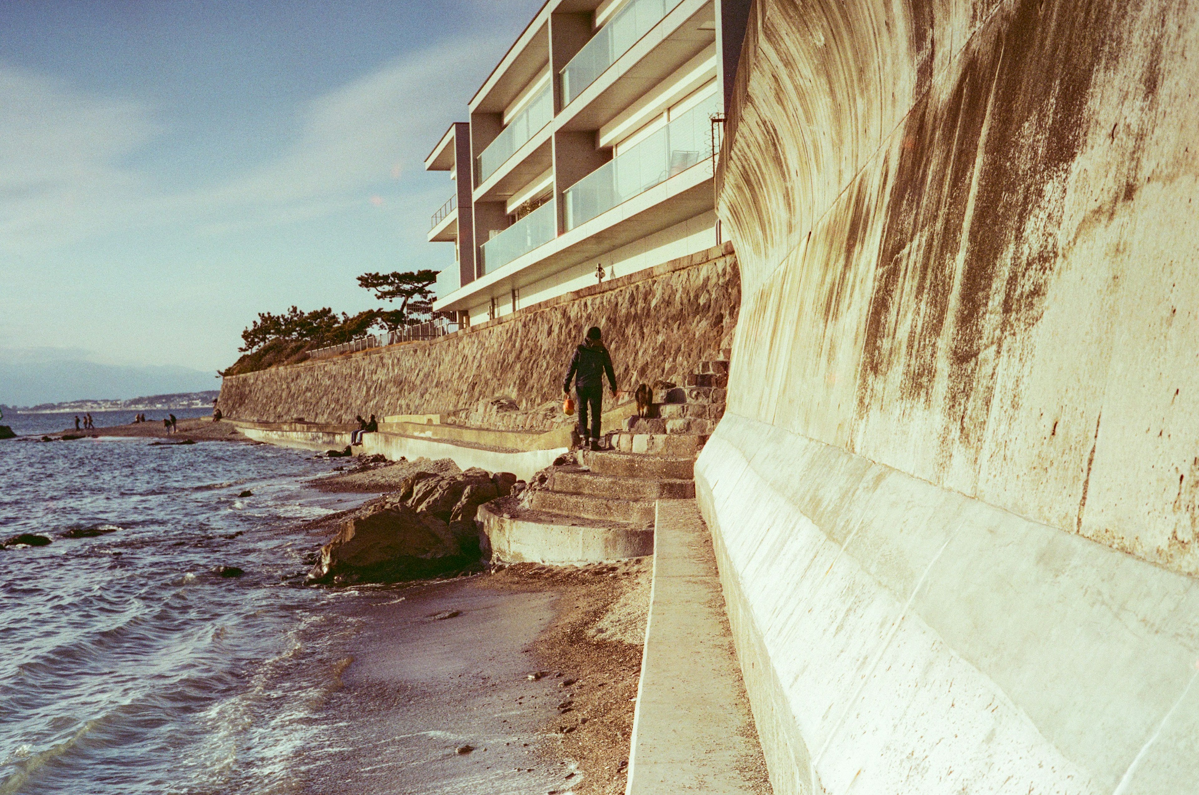 Coastal scene with a concrete wall and a person standing