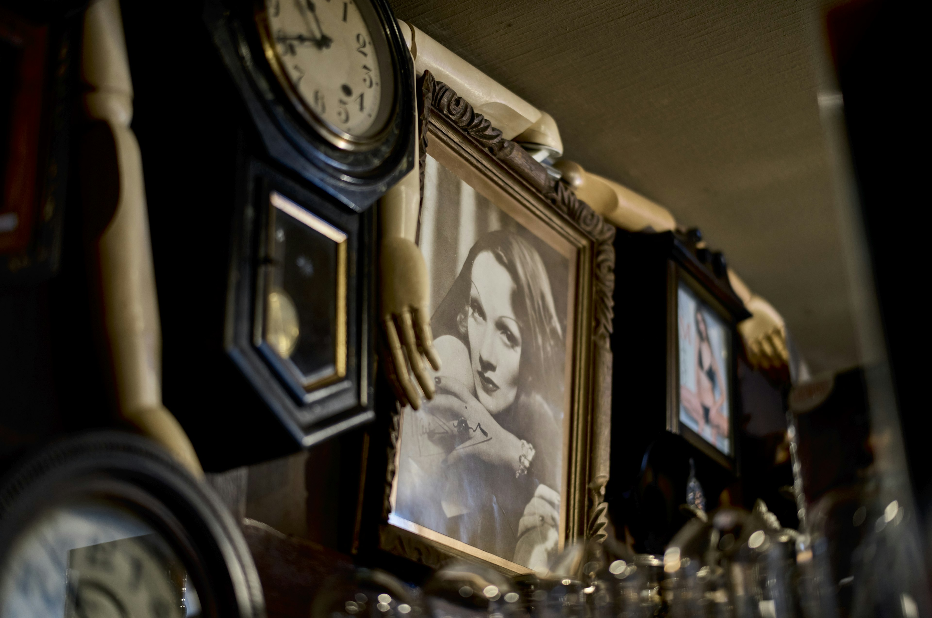 A section of a wall adorned with vintage photographs and clocks