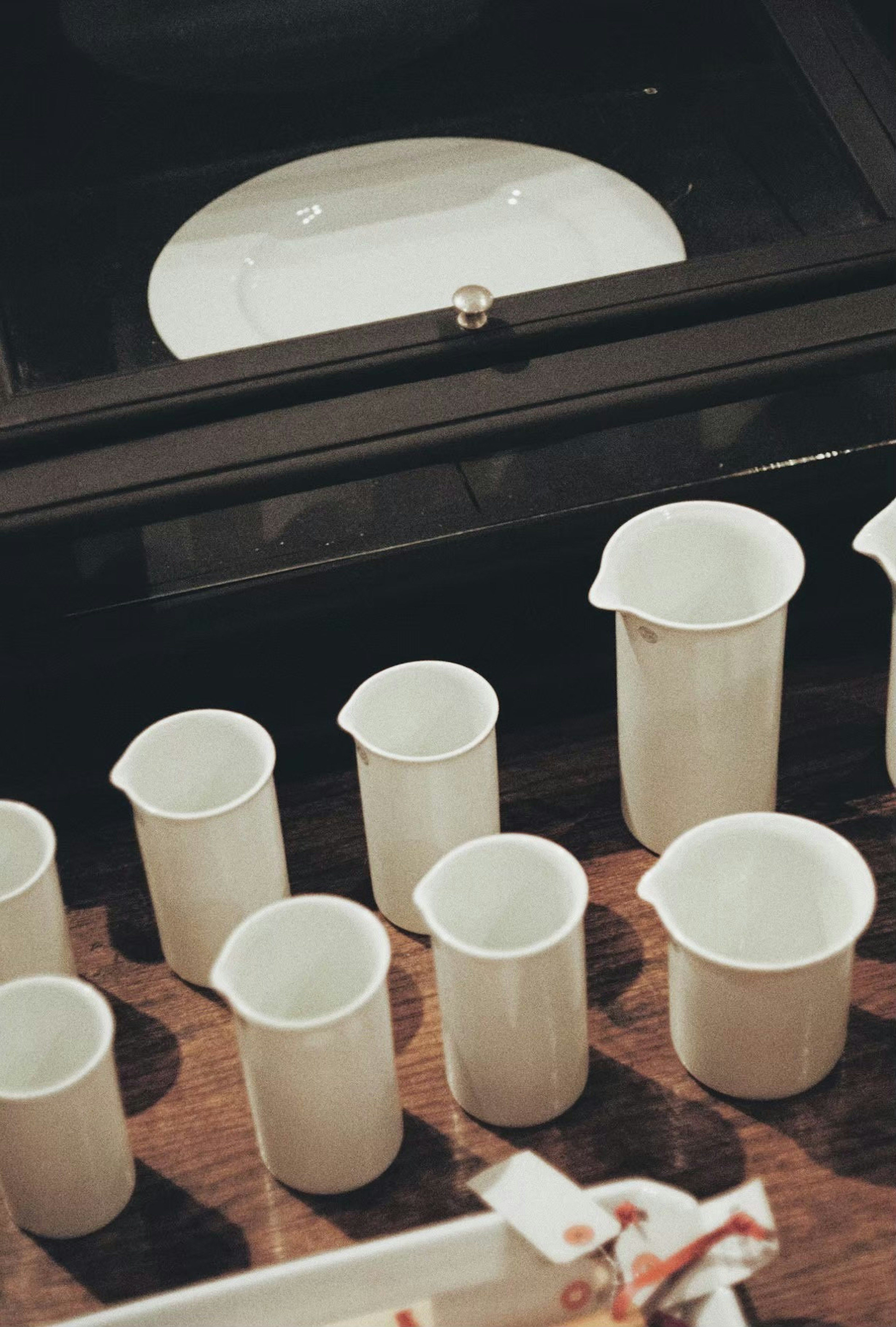 A collection of white measuring cups arranged on a wooden surface