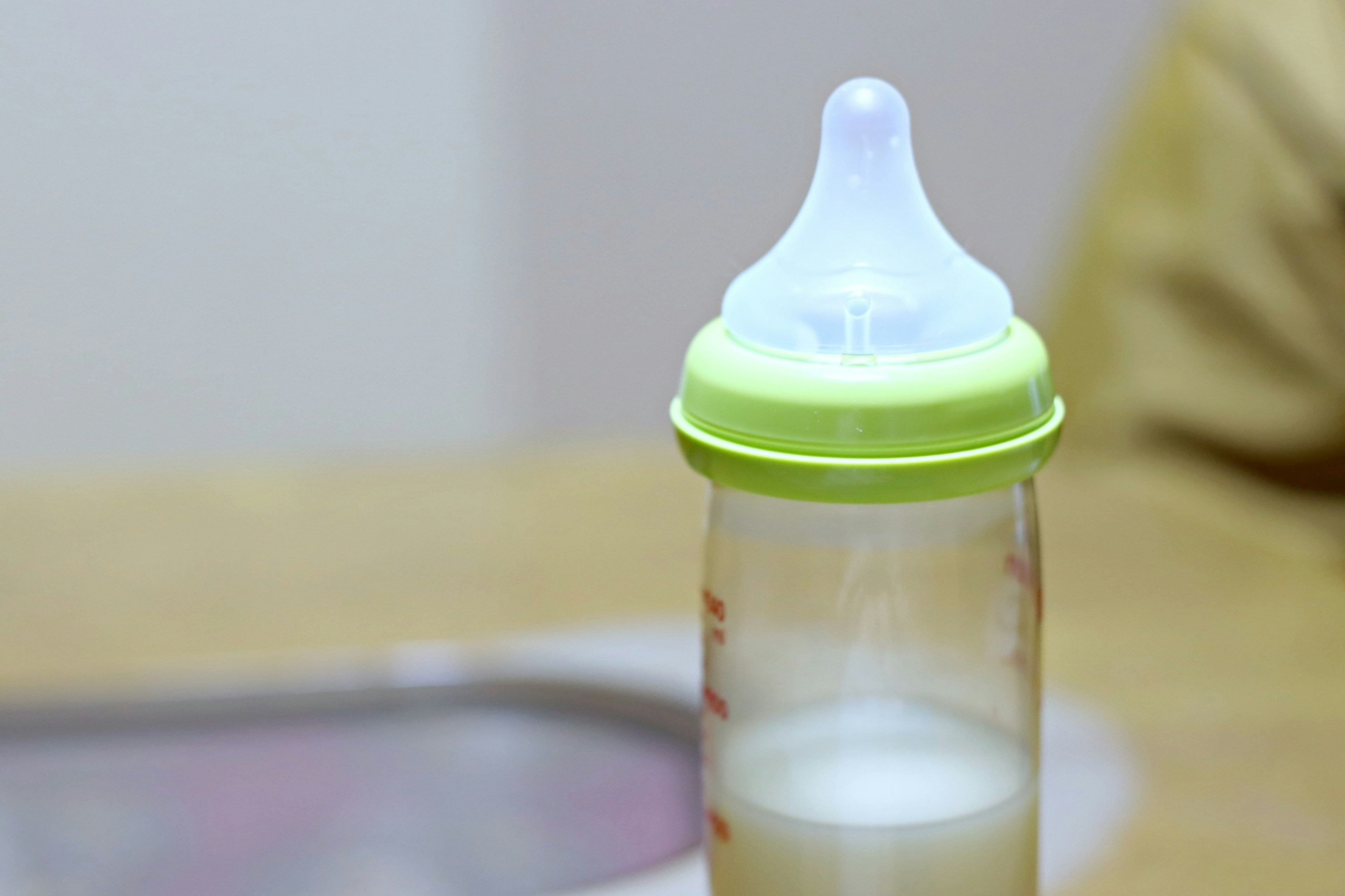 Baby bottle with green cap and white nipple