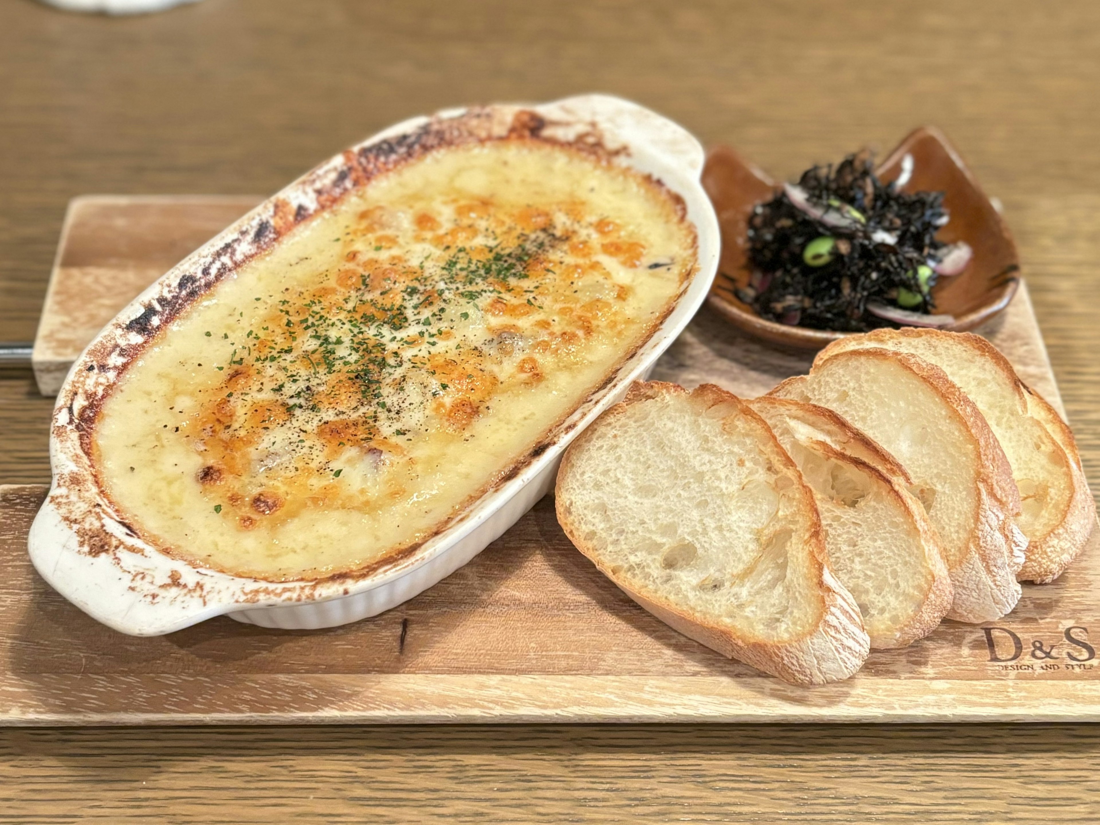 Creamy gratin with toasted bread and a side of seaweed salad