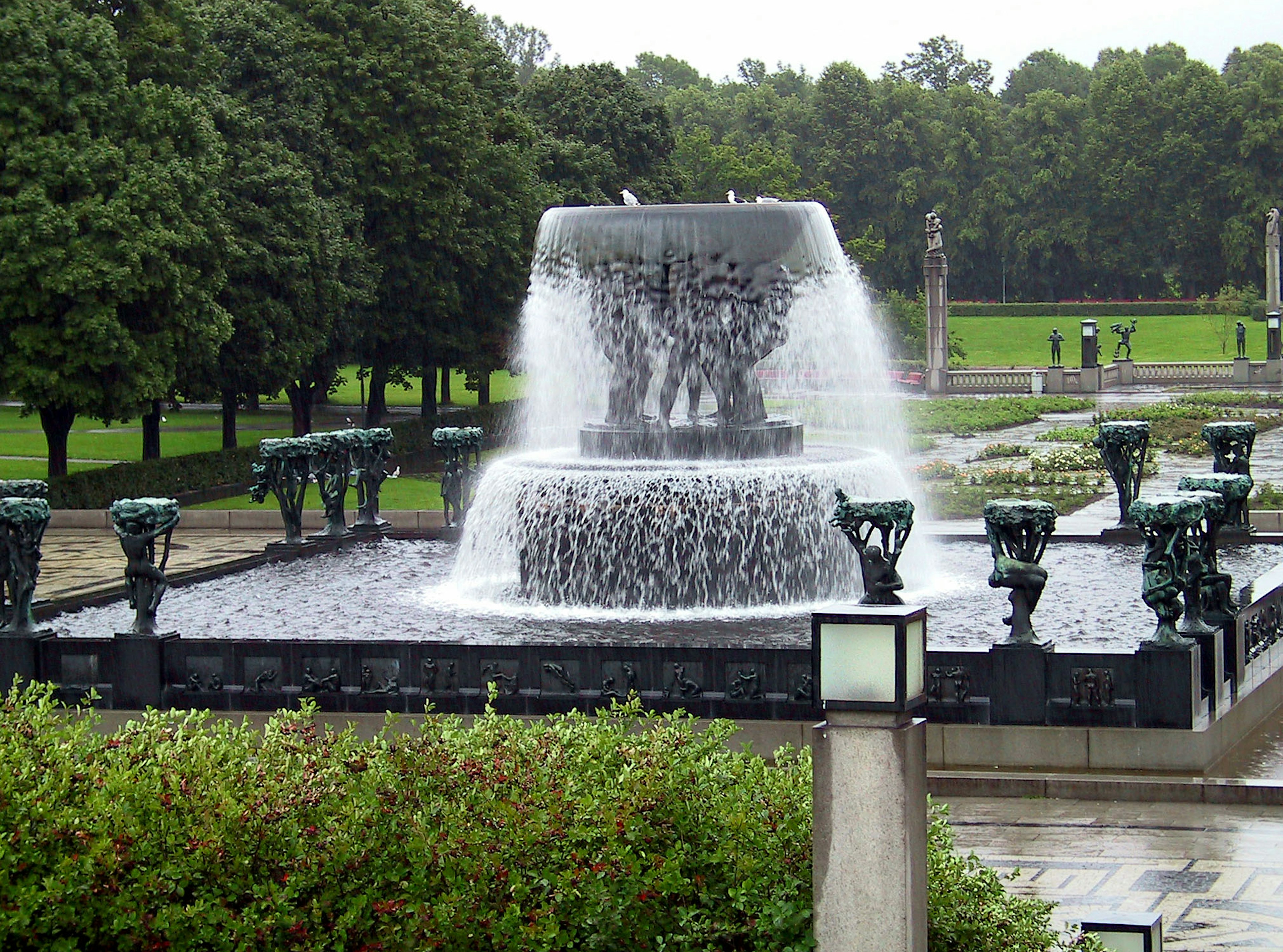 Una bella fontana al centro circondata da alberi verdi lussureggianti in un parco