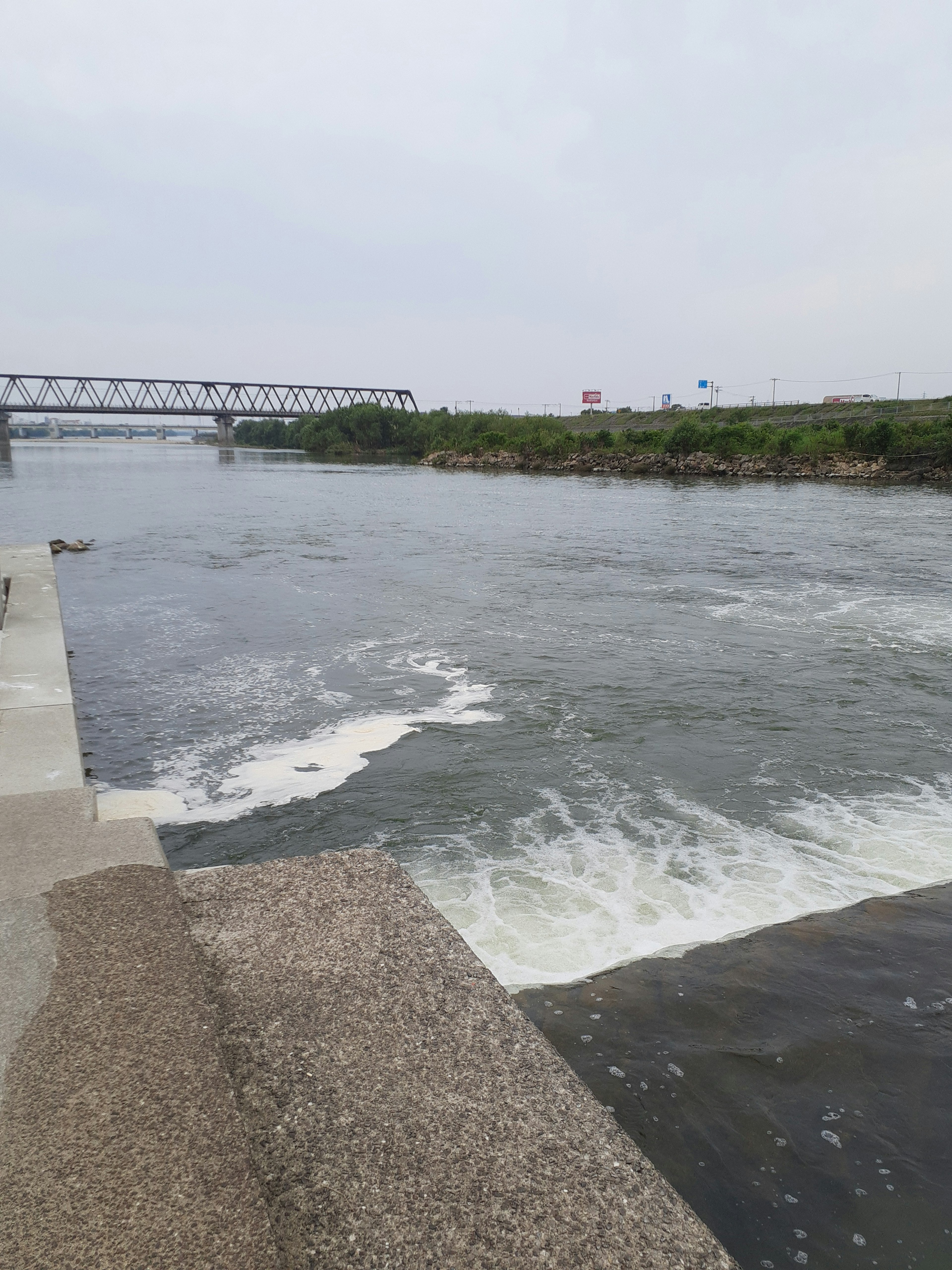 Scena tranquilla lungo il fiume con un ponte