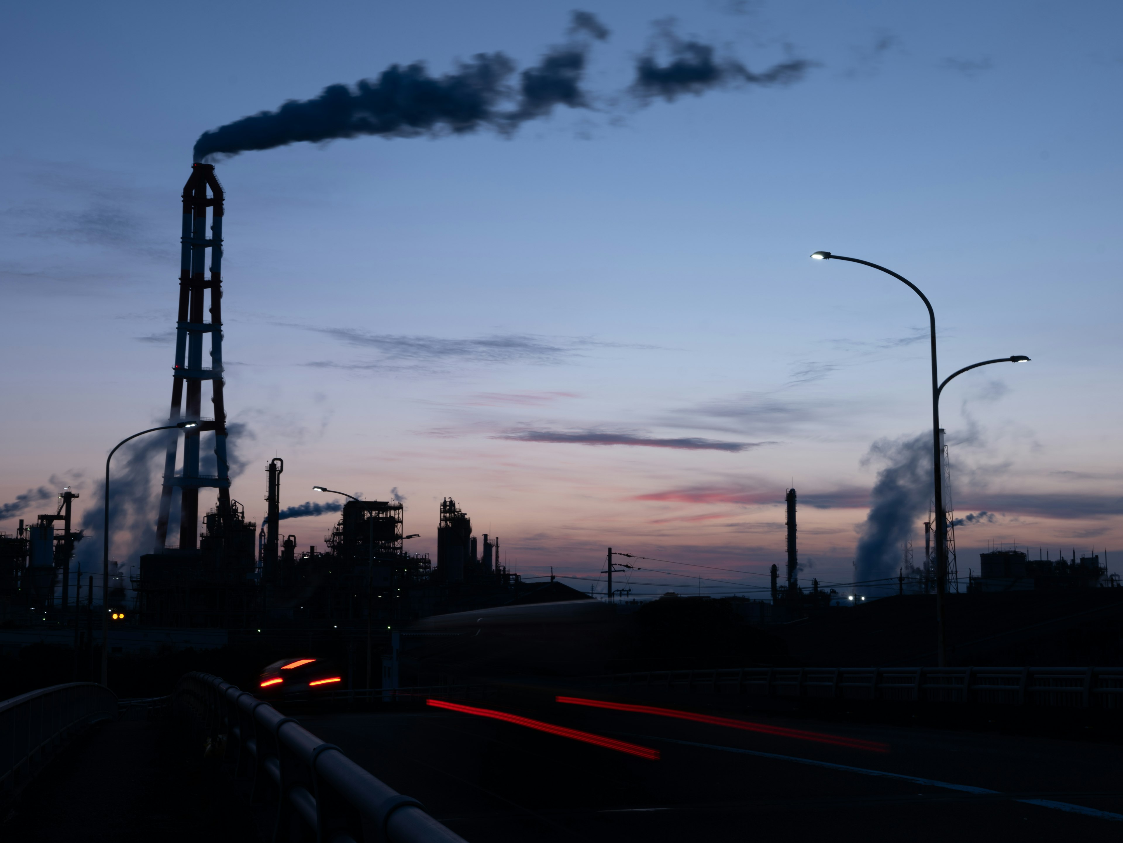 Paisaje industrial al atardecer con chimeneas y siluetas de fábricas