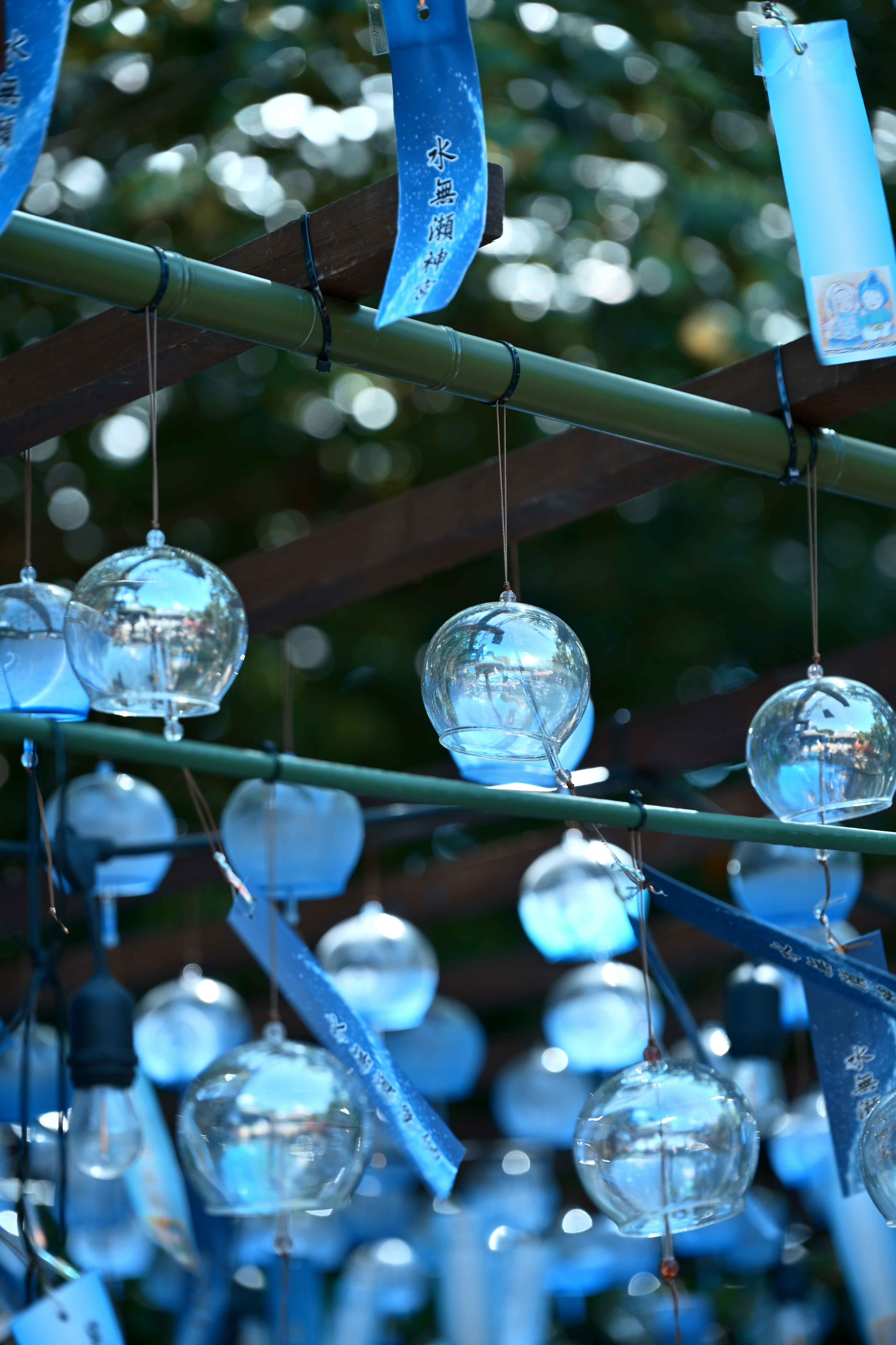 Une scène avec des carillons en verre bleus suspendus à une structure