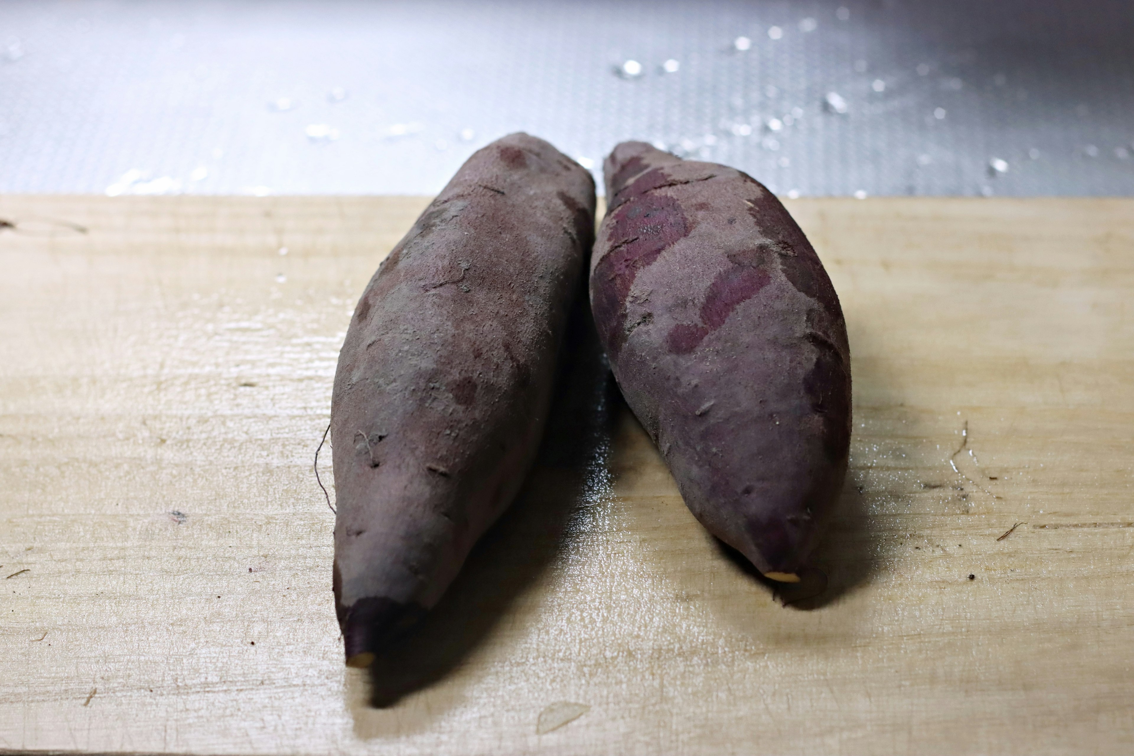 Dos batatas colocadas sobre una tabla de madera