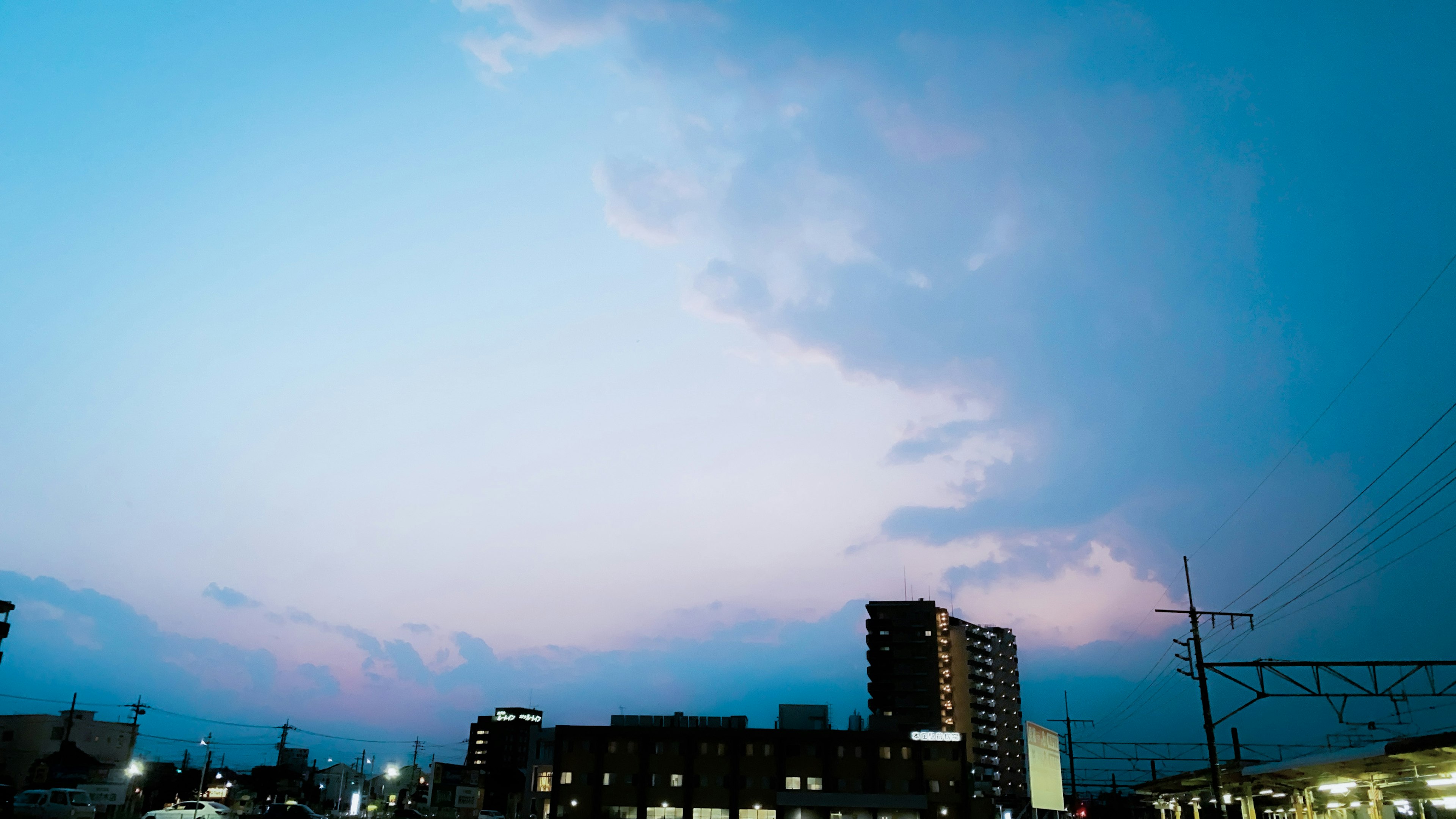 青い空と雲のある風景に建物が映える夕暮れ