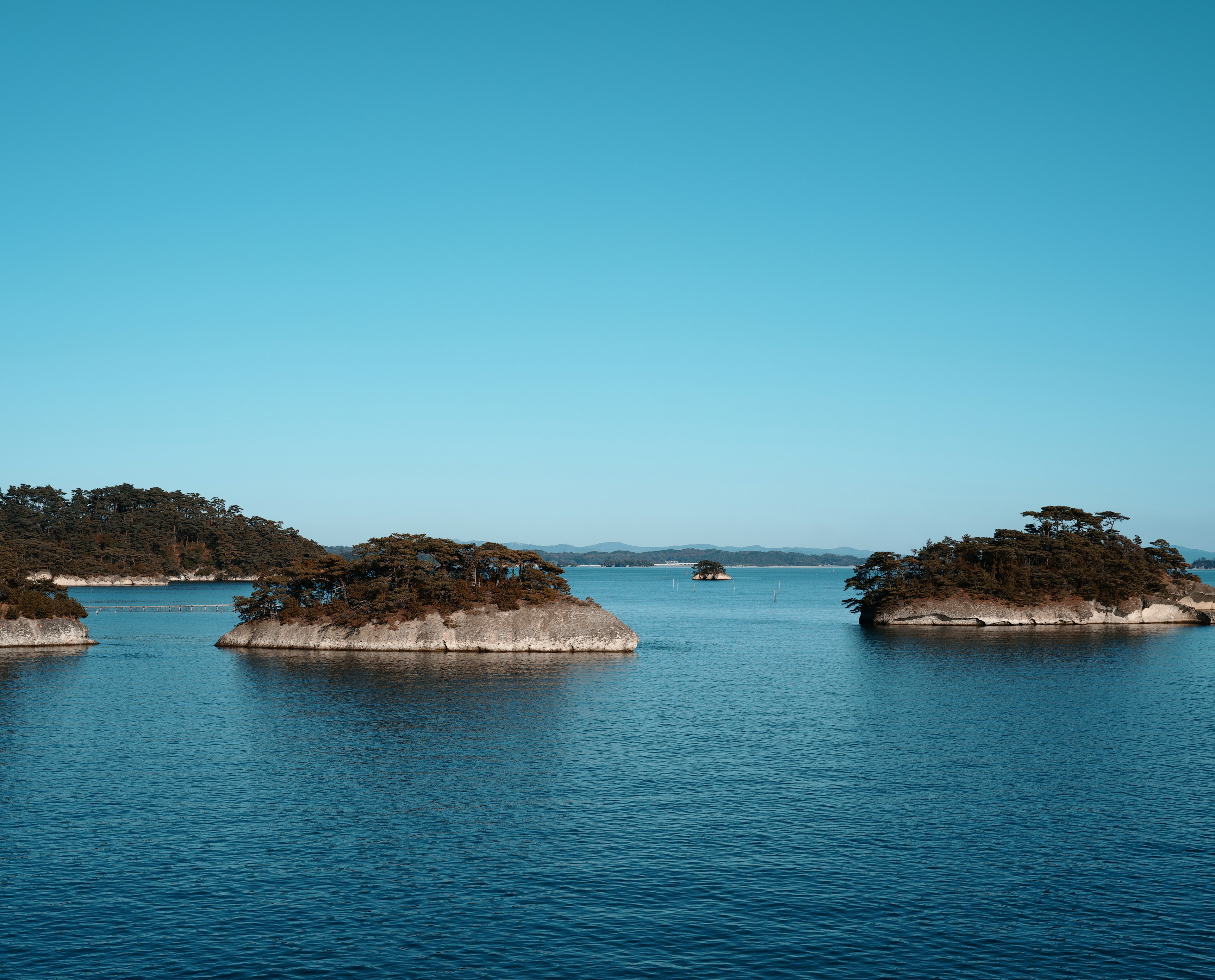 Vista escénica de aguas tranquilas y pequeñas islas a lo lejos