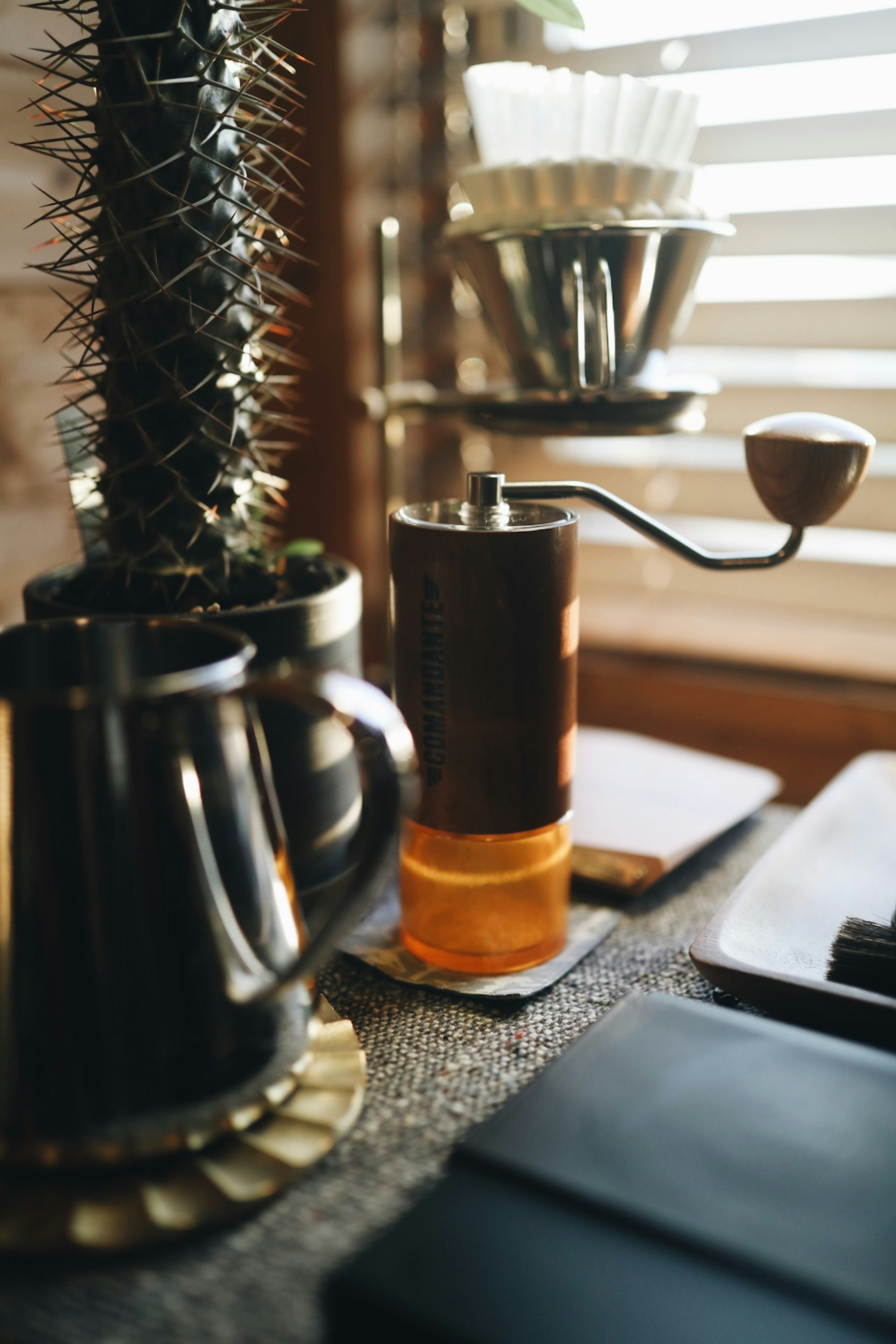 Molino de café y planta en una mesa de café