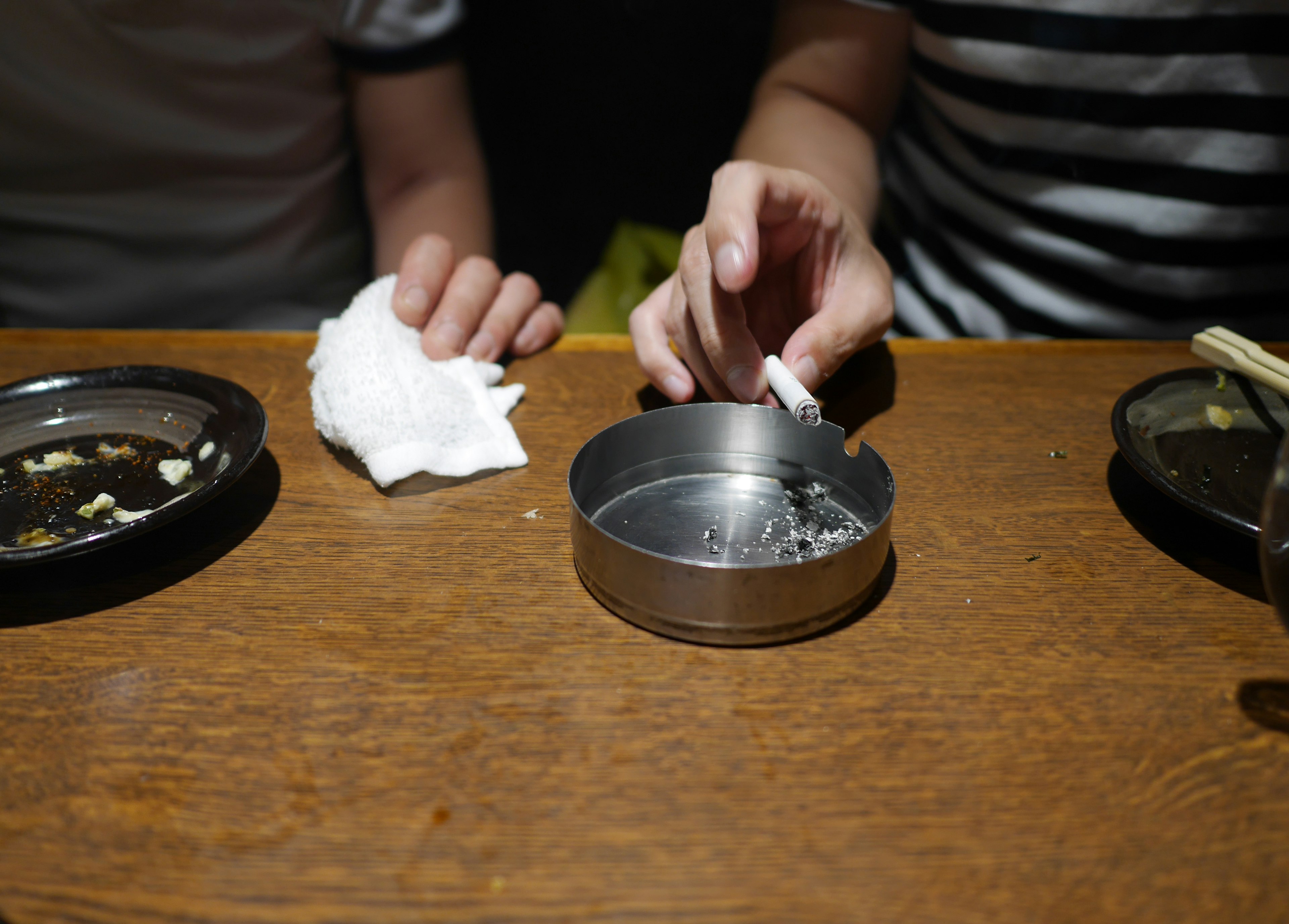 Image montrant des mains et des plats sur une table en bois