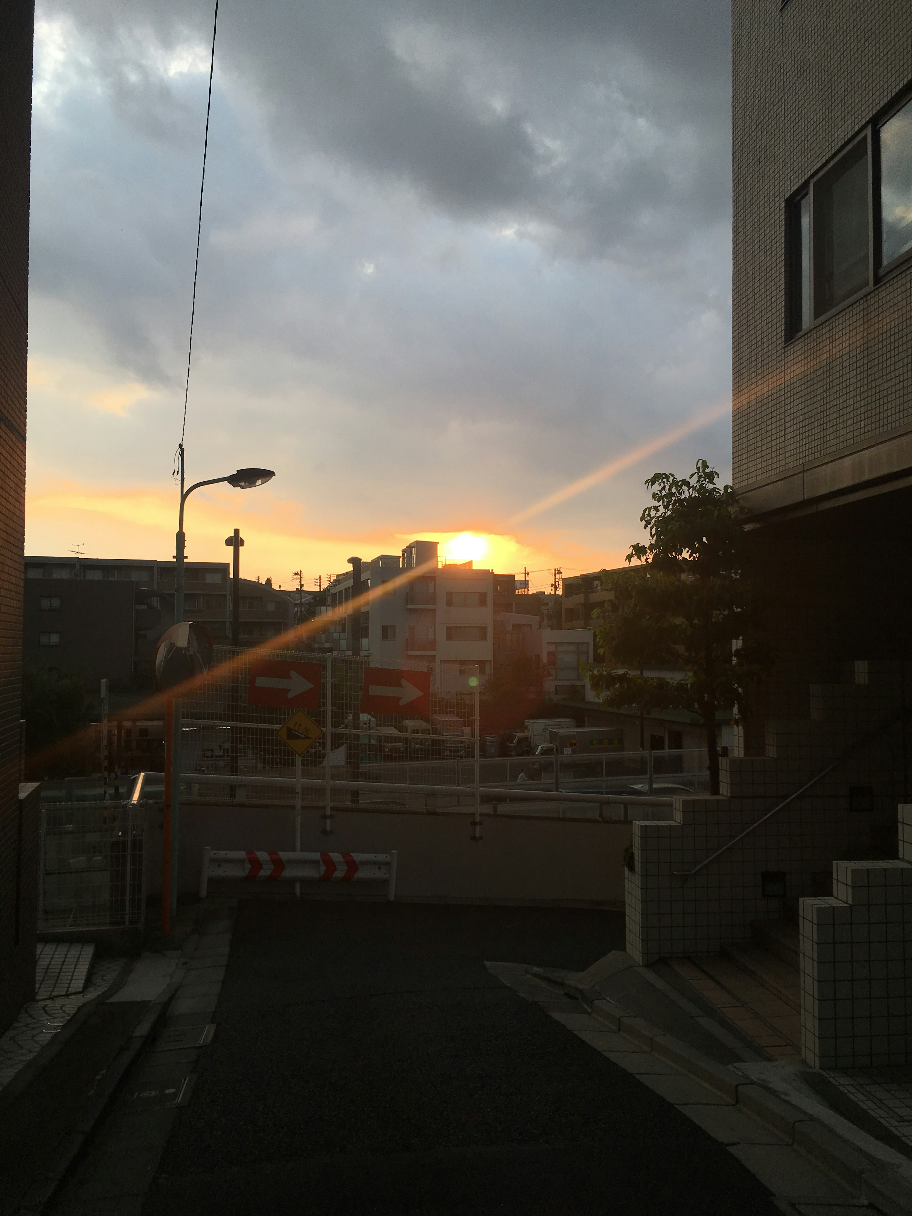 Scena urbana con il tramonto che appare tra le nuvole