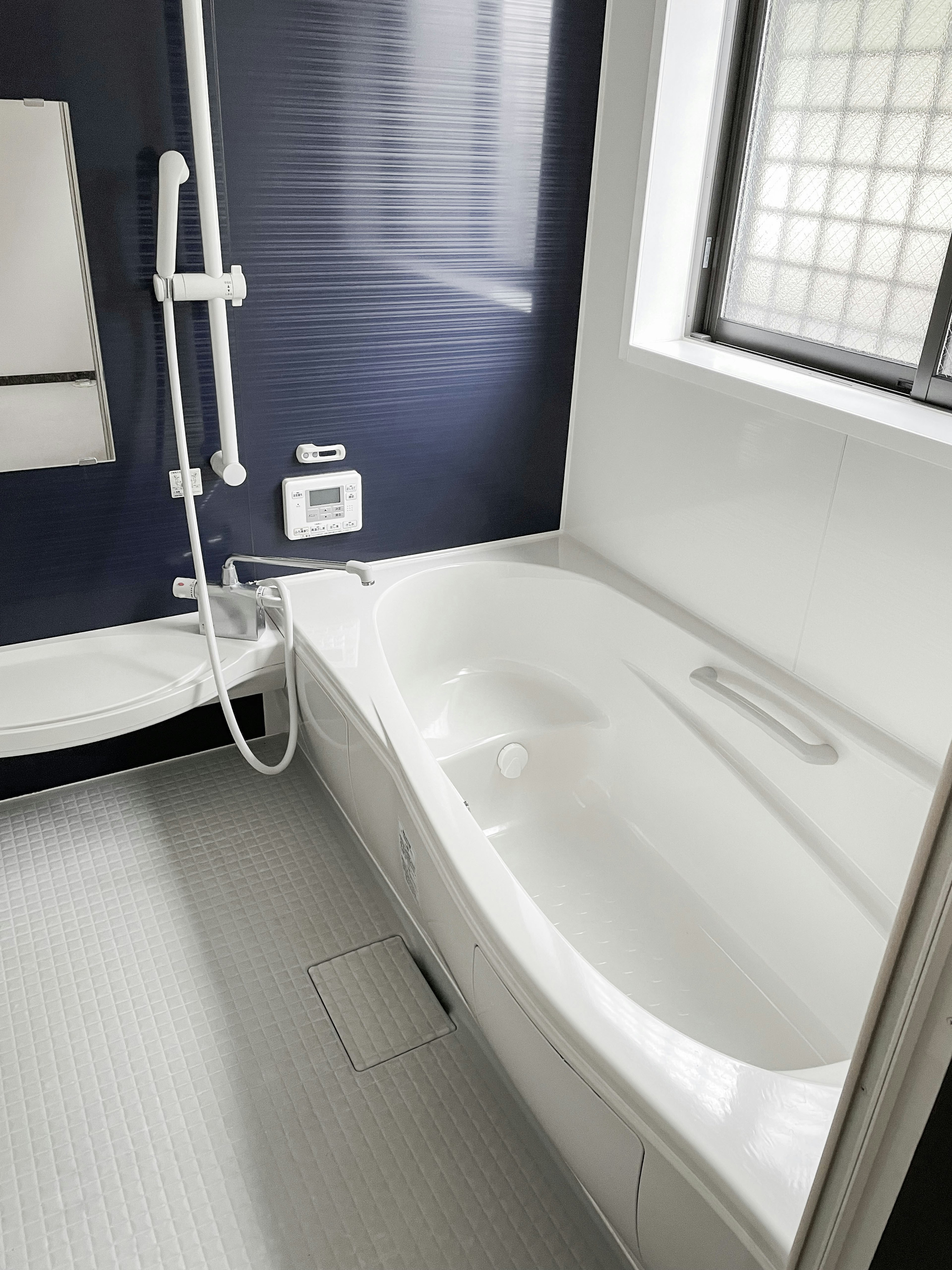 Salle de bain moderne avec baignoire blanche et douche dans un design minimaliste