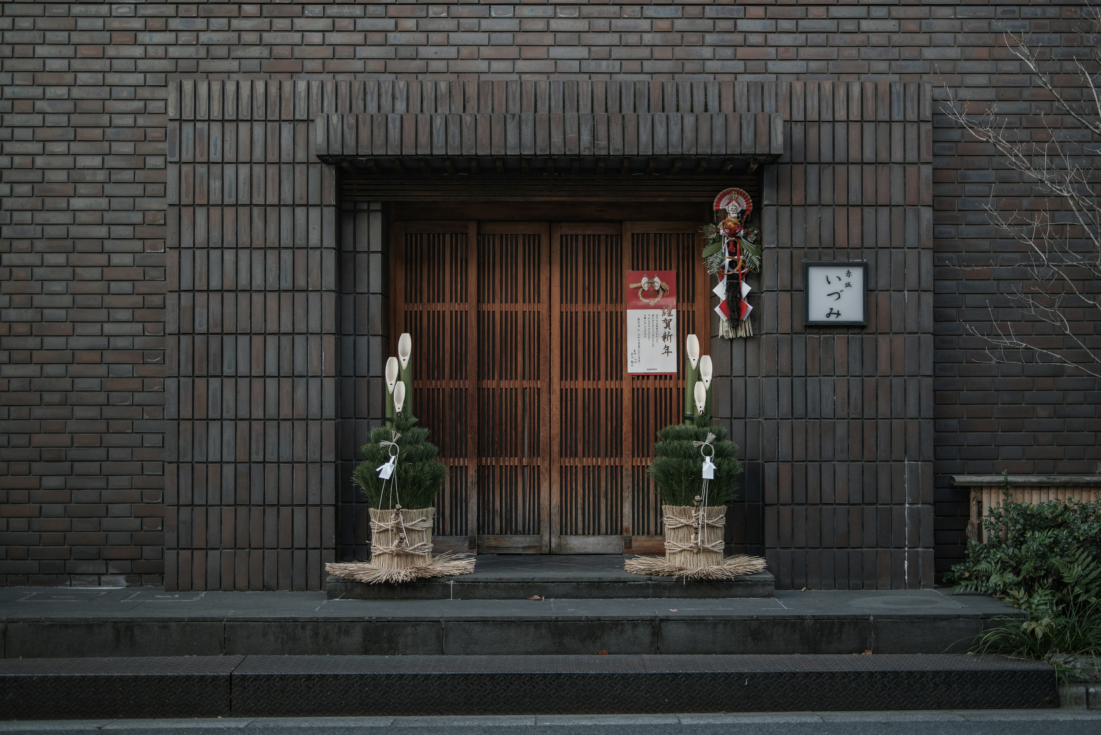 传统日本入口，配有木门和竹子装饰