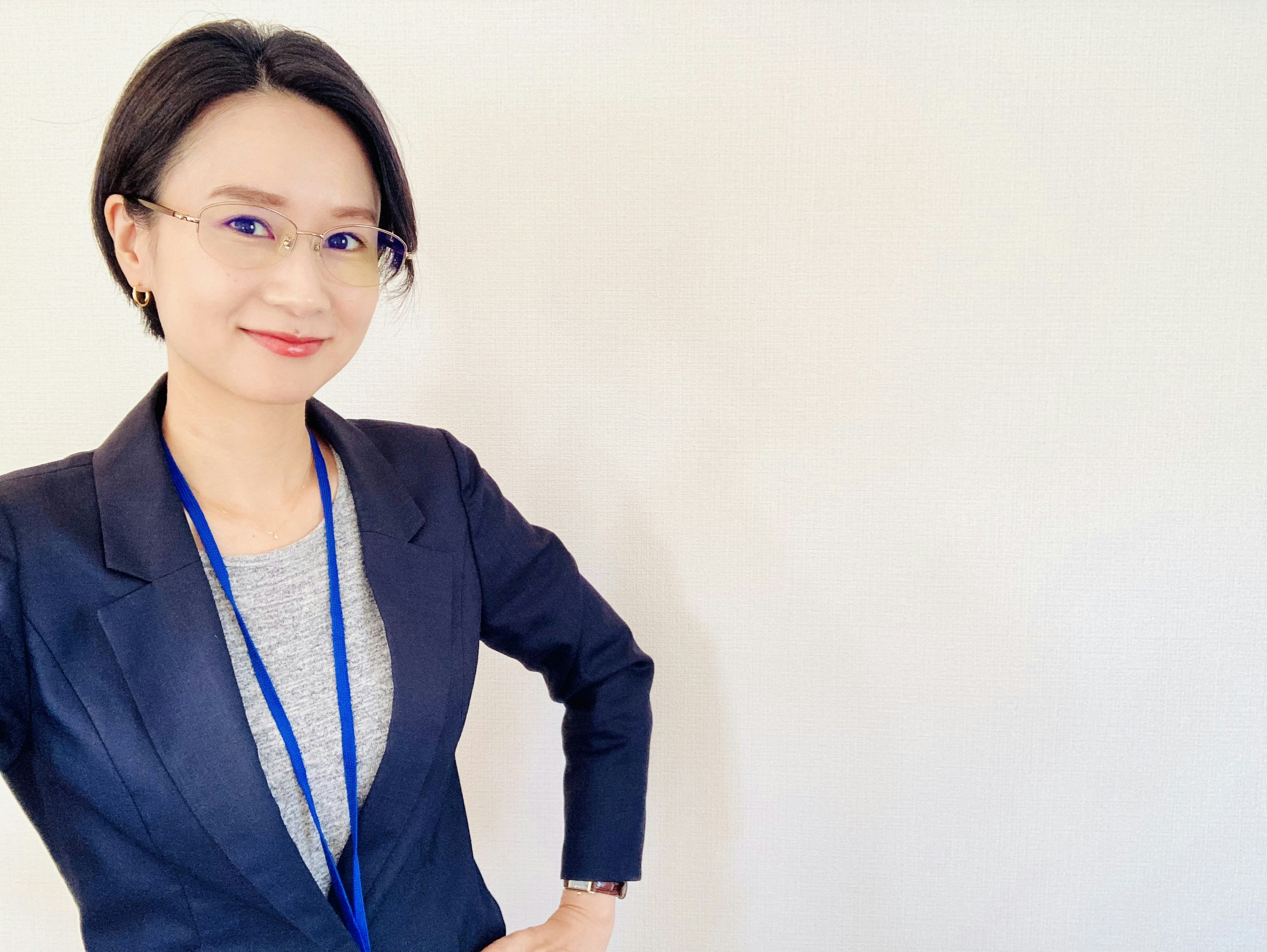 A woman in a business suit smiling and standing confidently