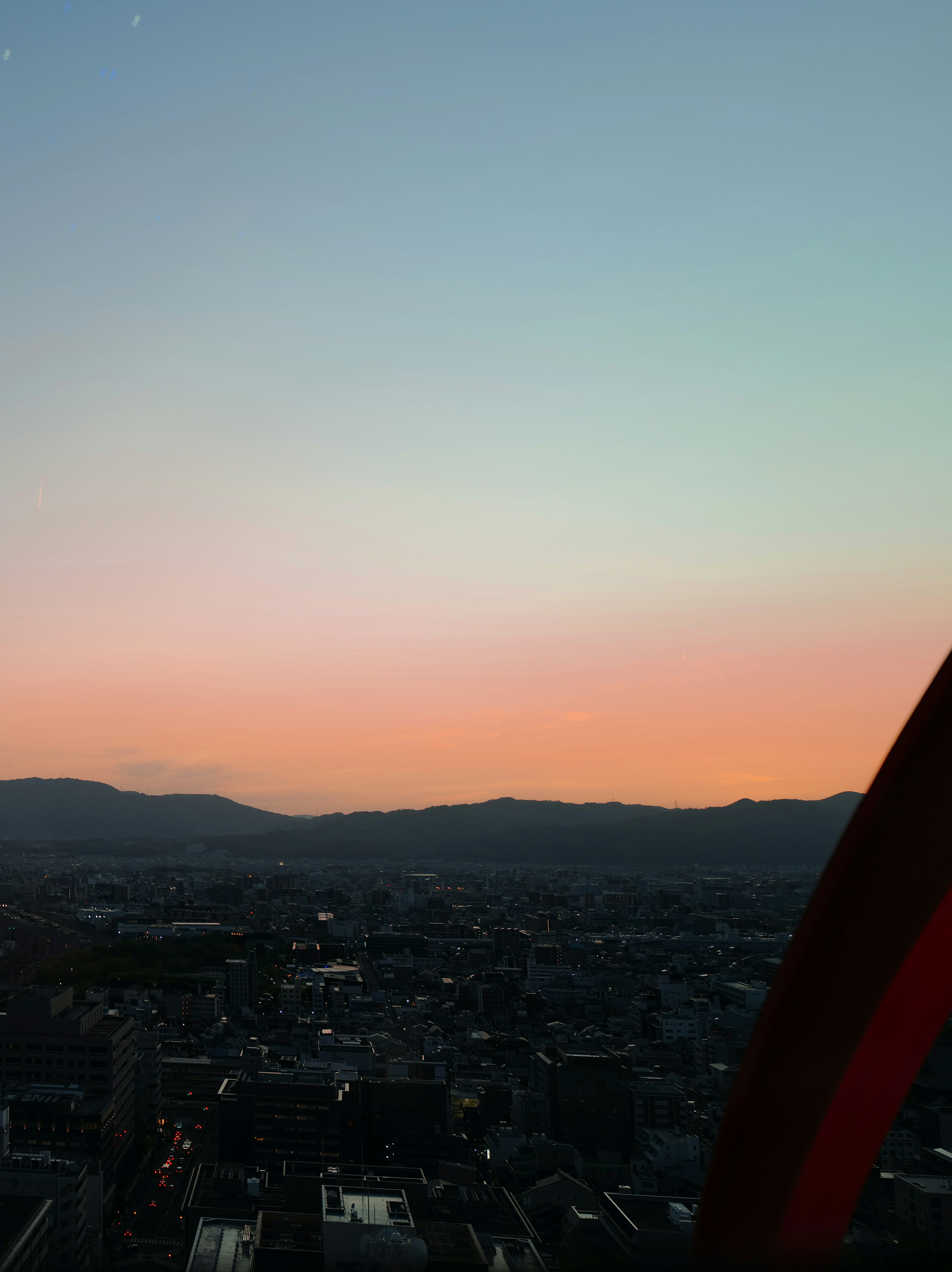 Paysage urbain au coucher du soleil avec silhouettes de montagnes