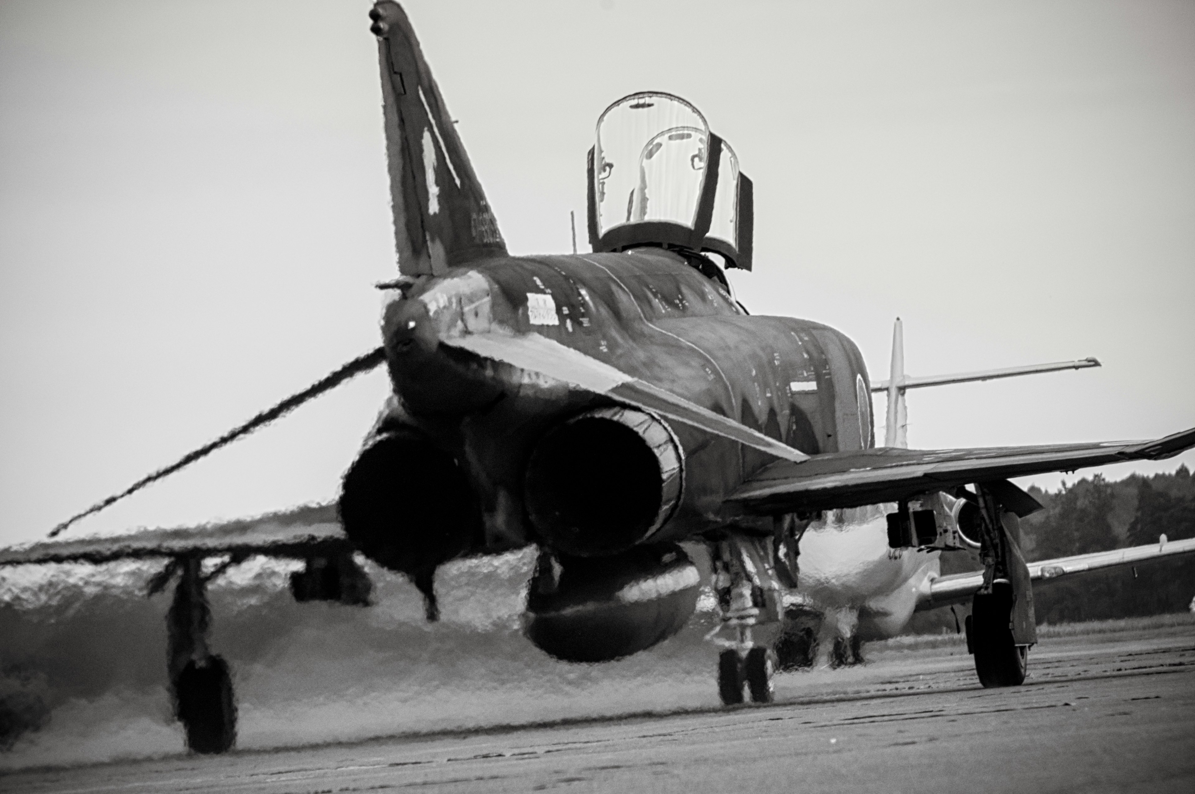 Jet militer bersiap lepas landas di landasan dalam foto hitam putih