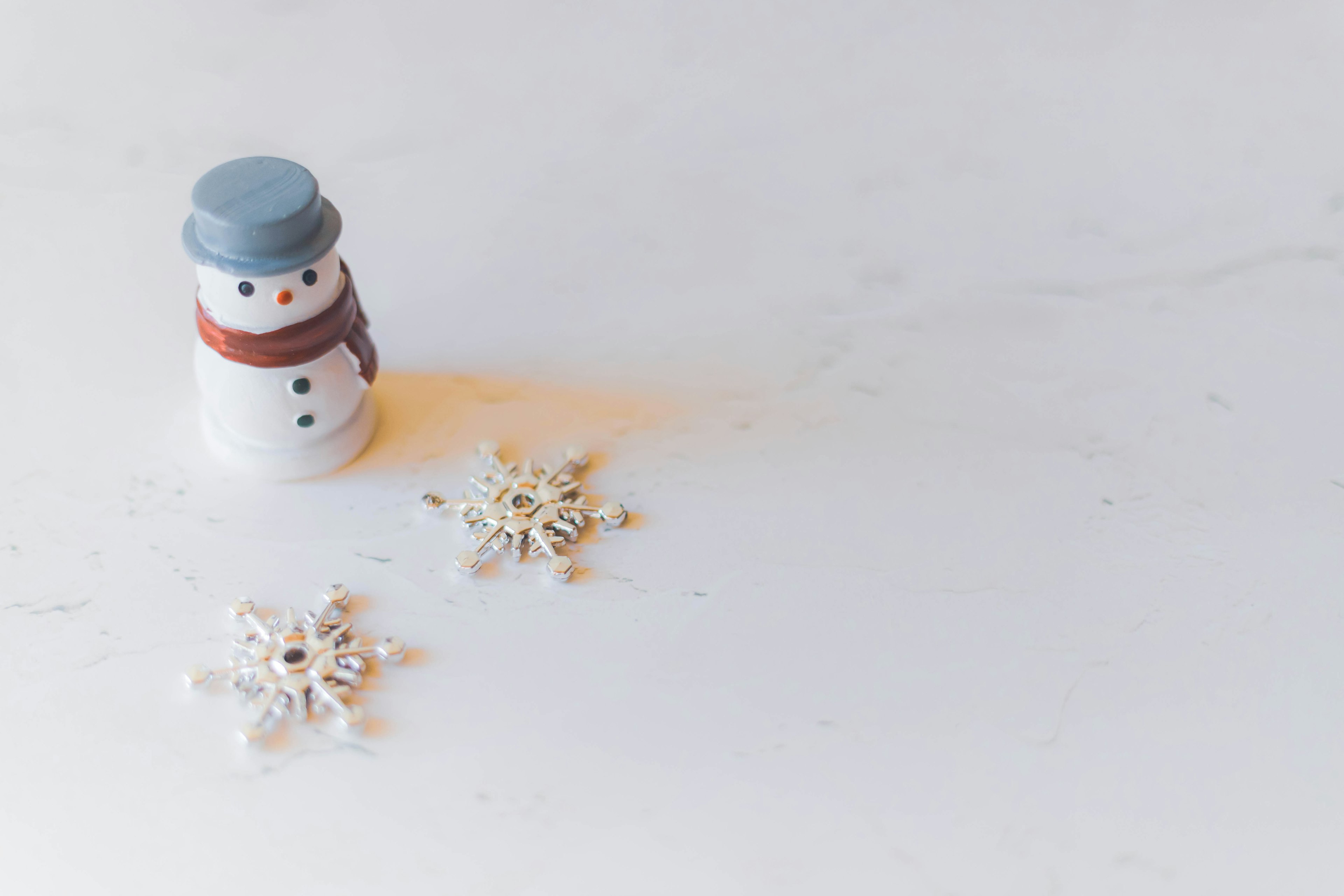 A winter decoration featuring a snowman and snowflakes on a white background