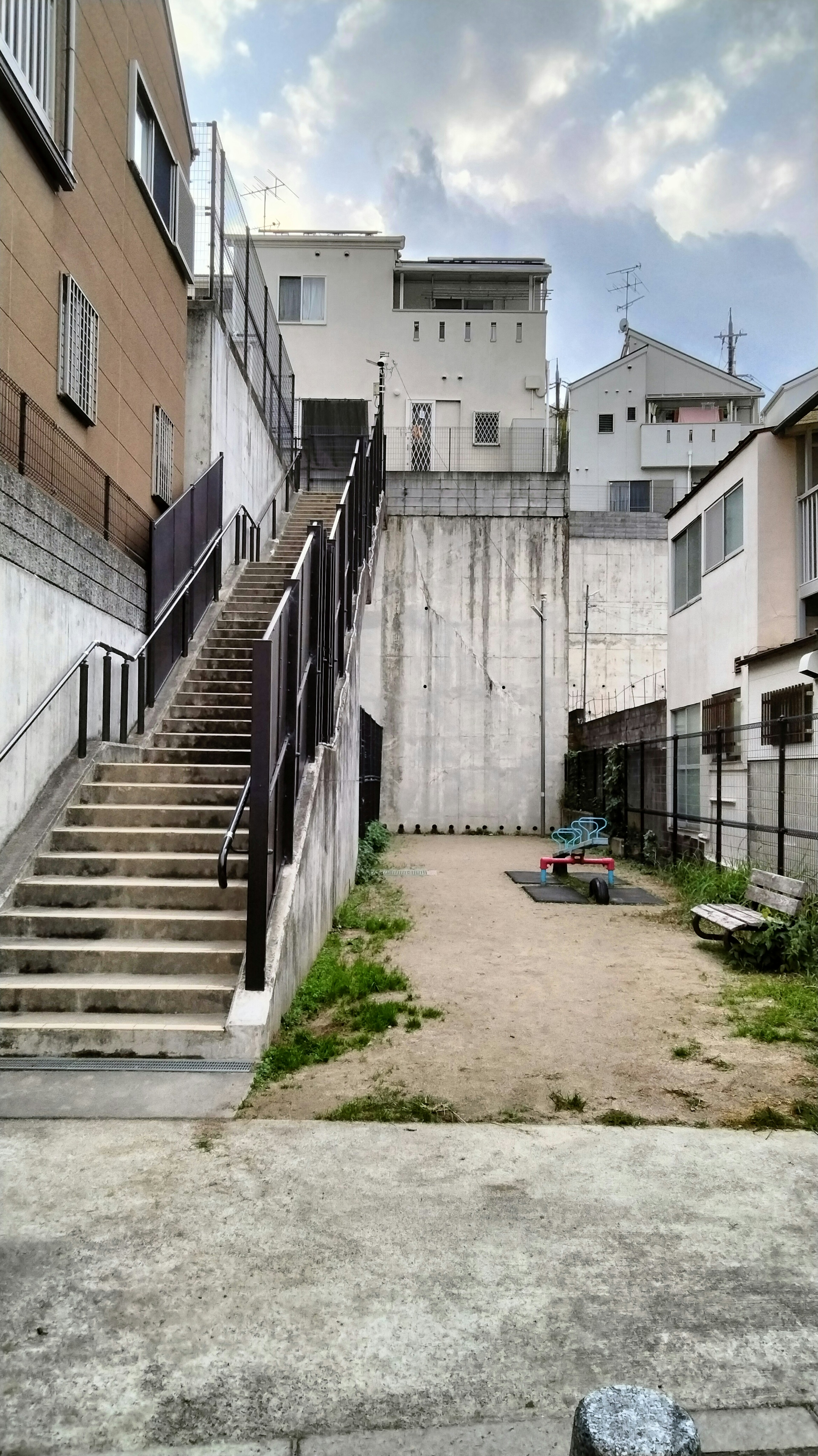 階段とコンクリートの壁がある住宅エリアの風景