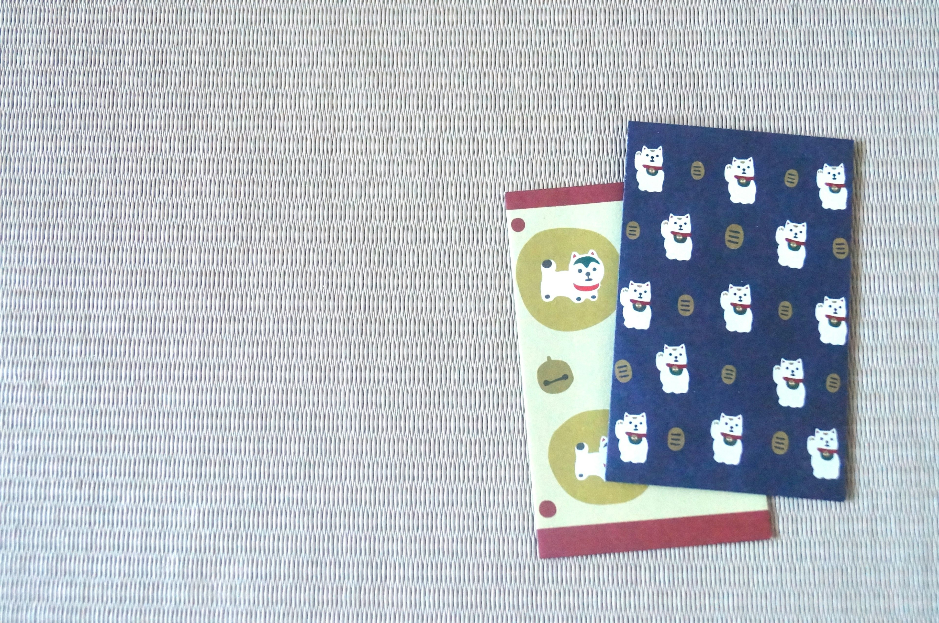 Two cute notebooks stacked with a simple fabric background