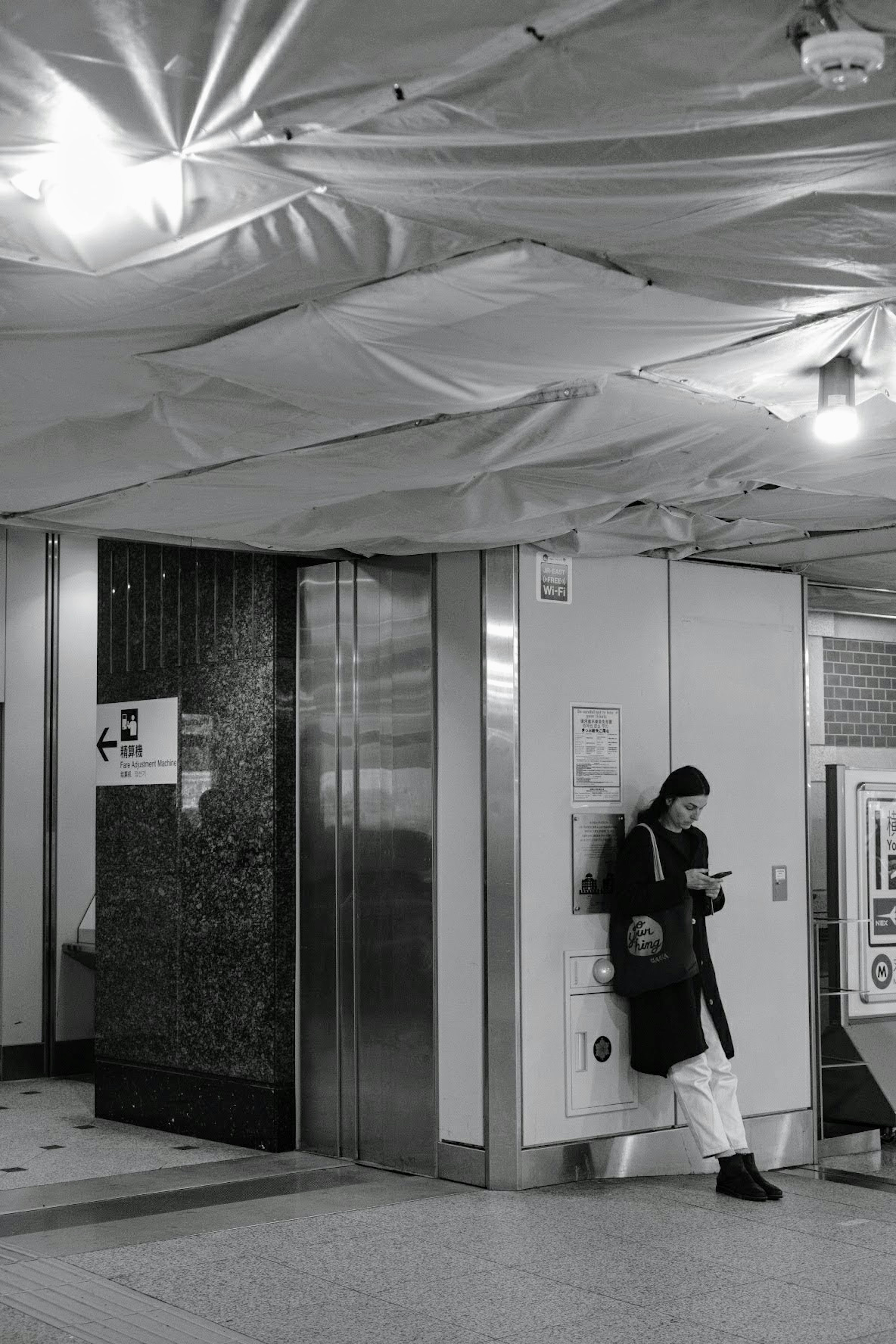 地下鉄の駅の一角で待っている男性とエレベーターの風景