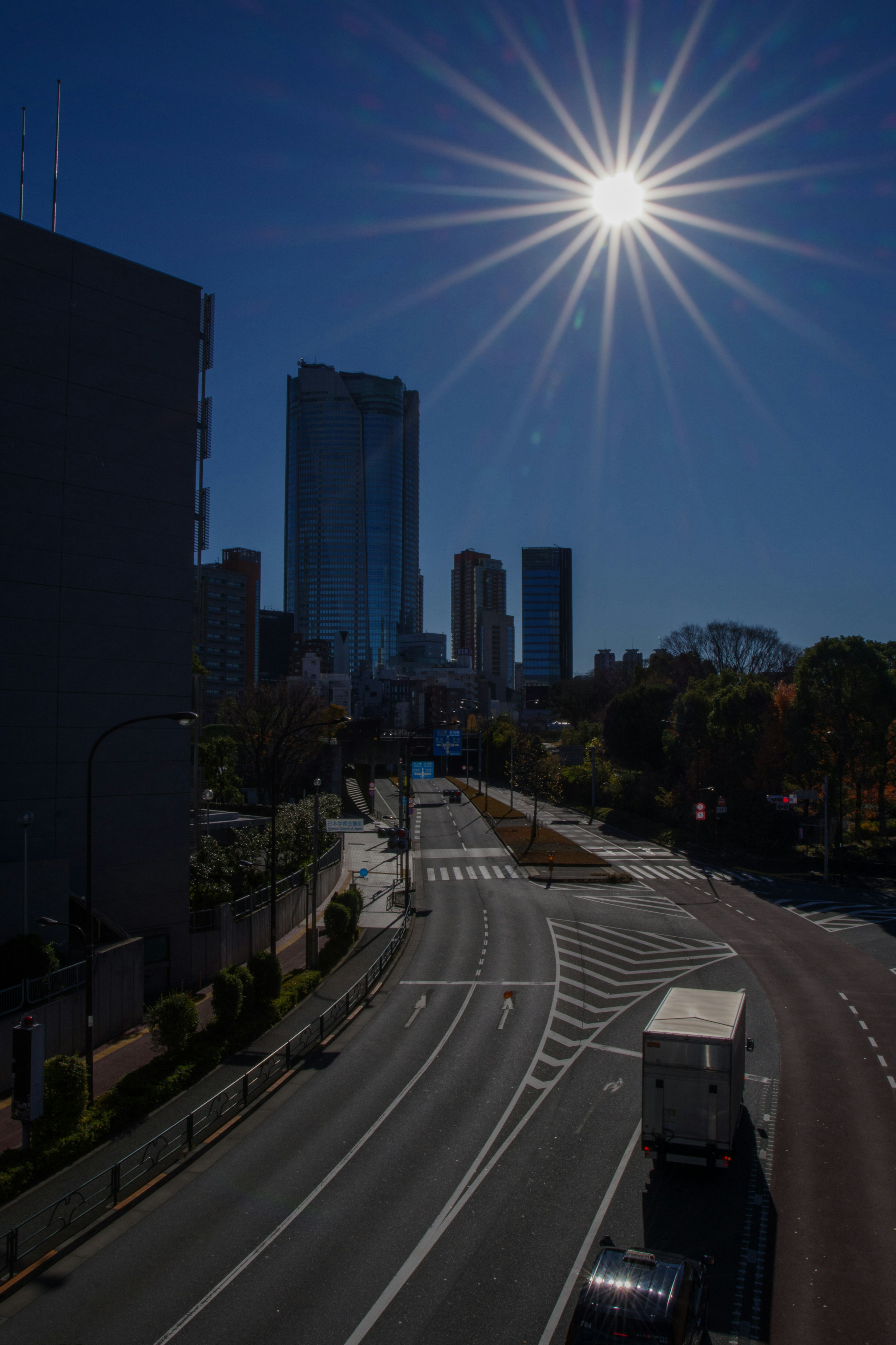 高層ビルと明るい太陽の下の都市の道路