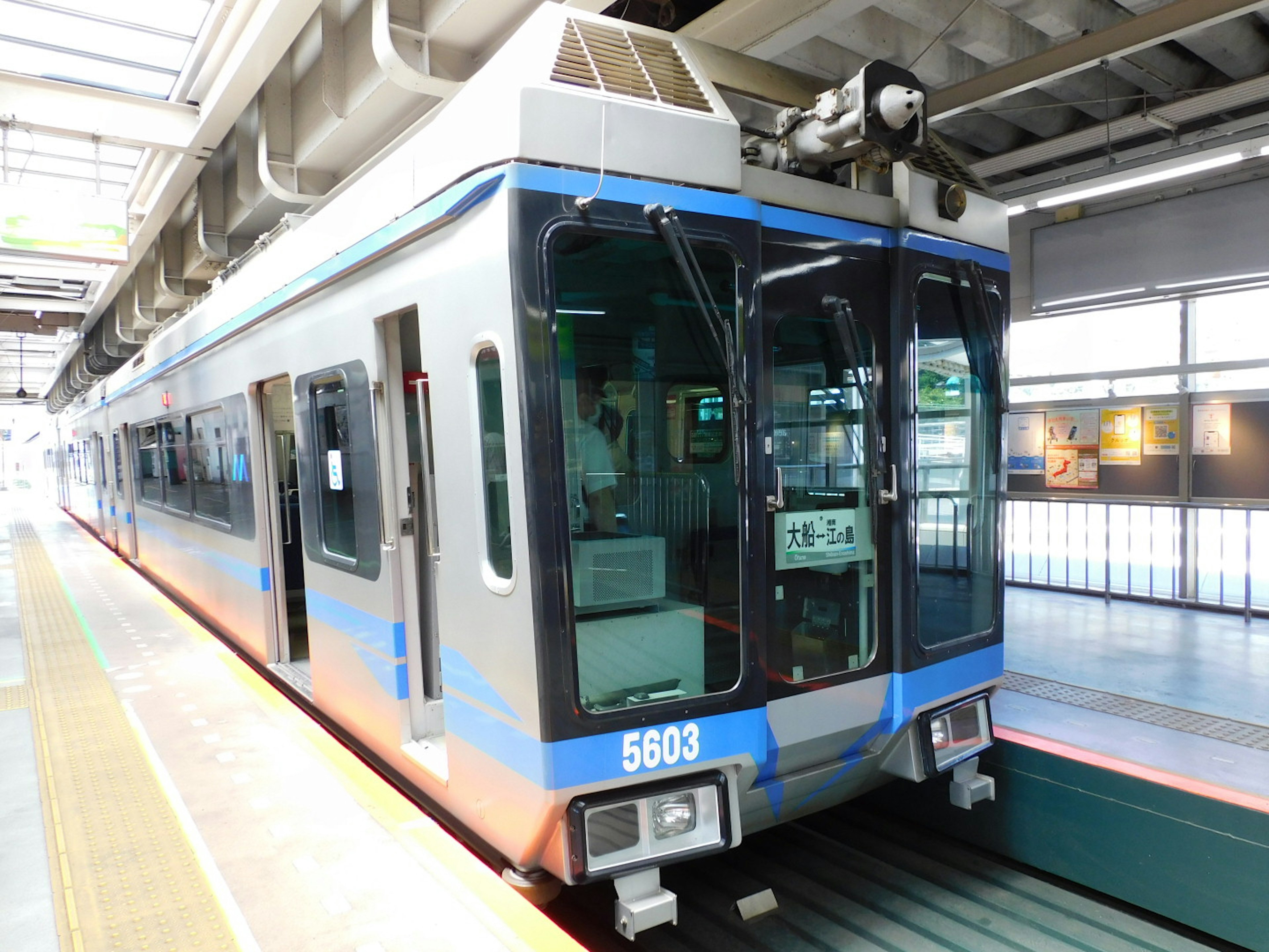 Kereta dengan garis biru diparkir di stasiun