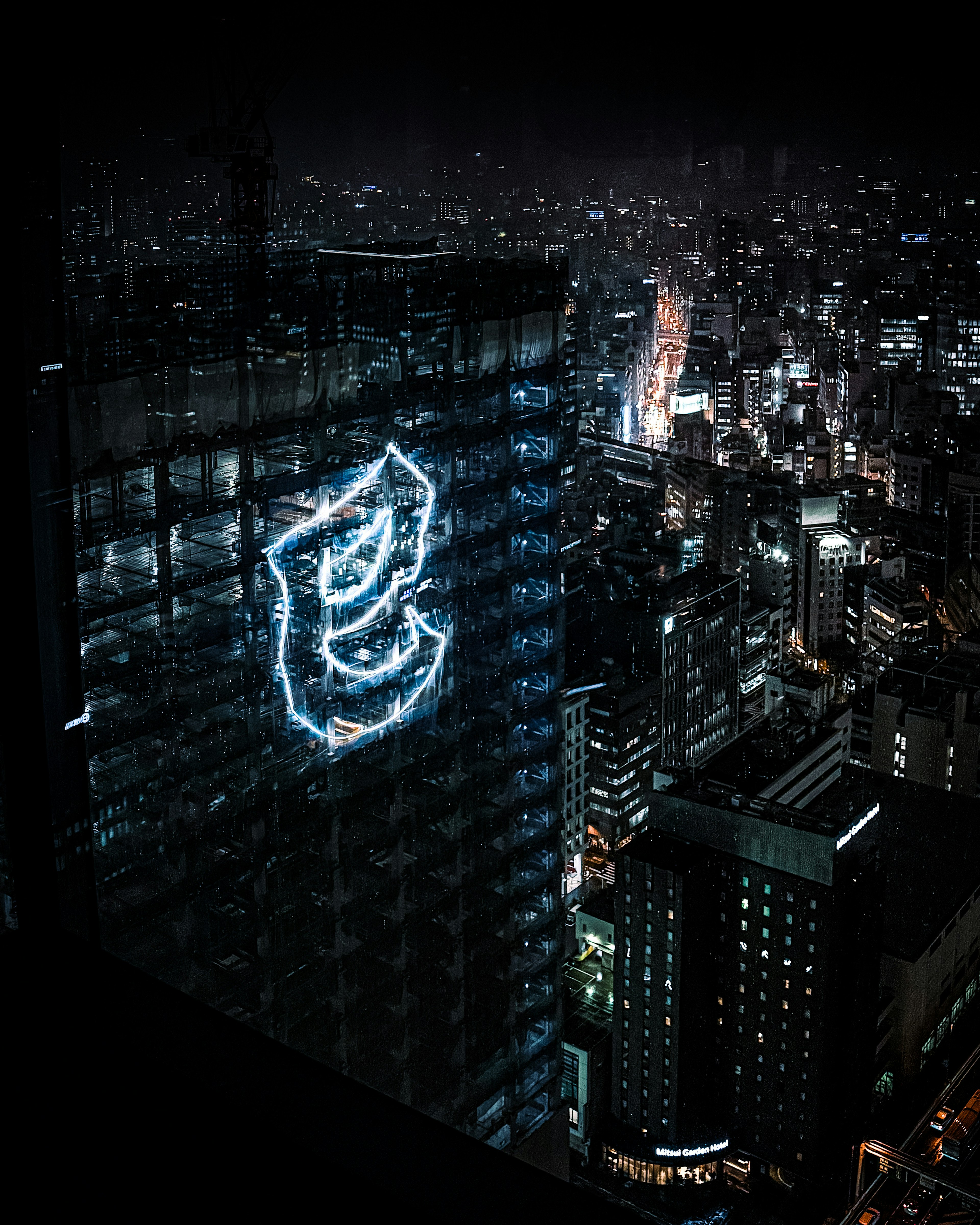 Vista nocturna de la ciudad con un edificio con caracteres iluminados