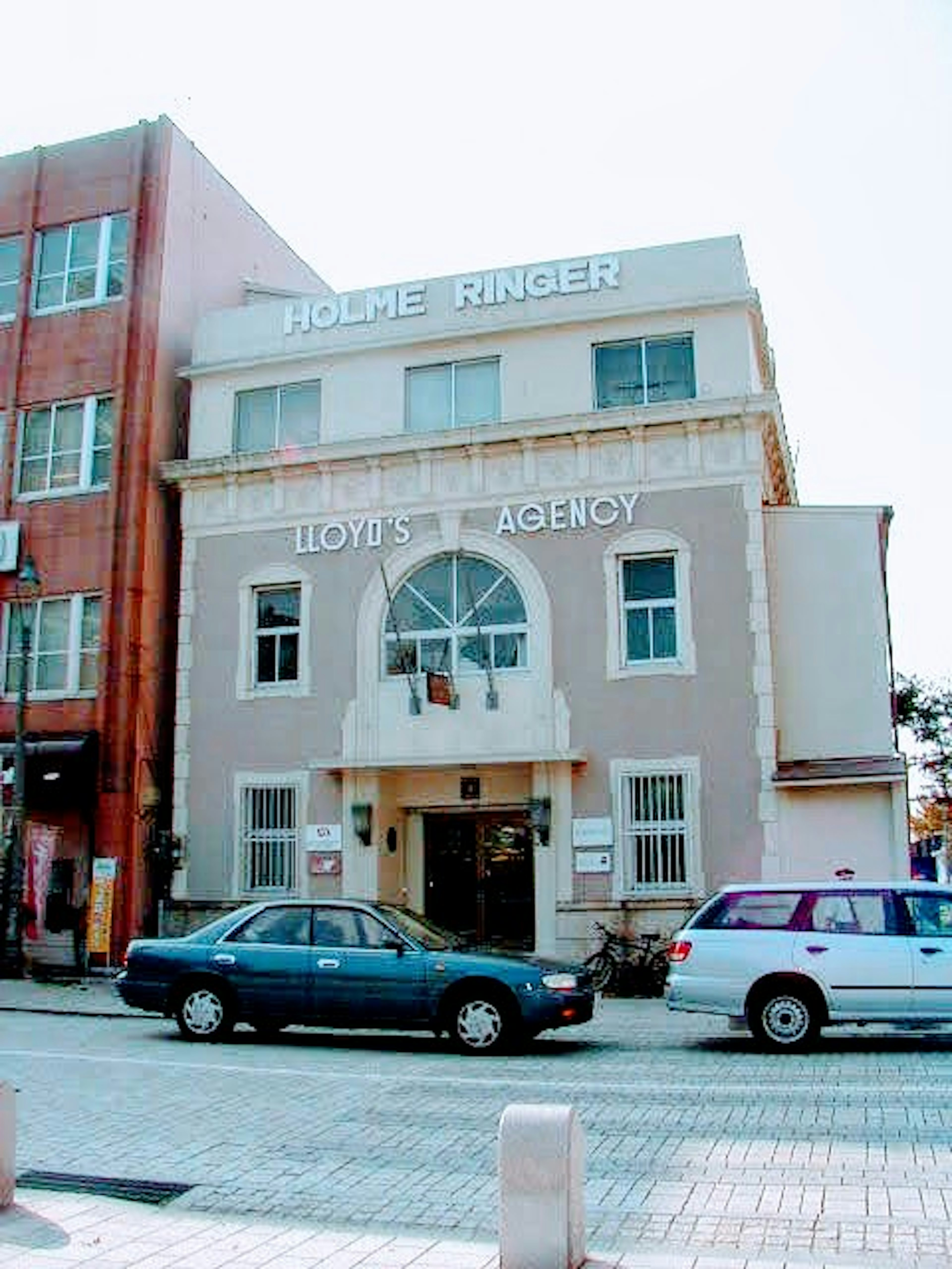 Facade of a ticket agency building with multiple windows and a light-colored exterior