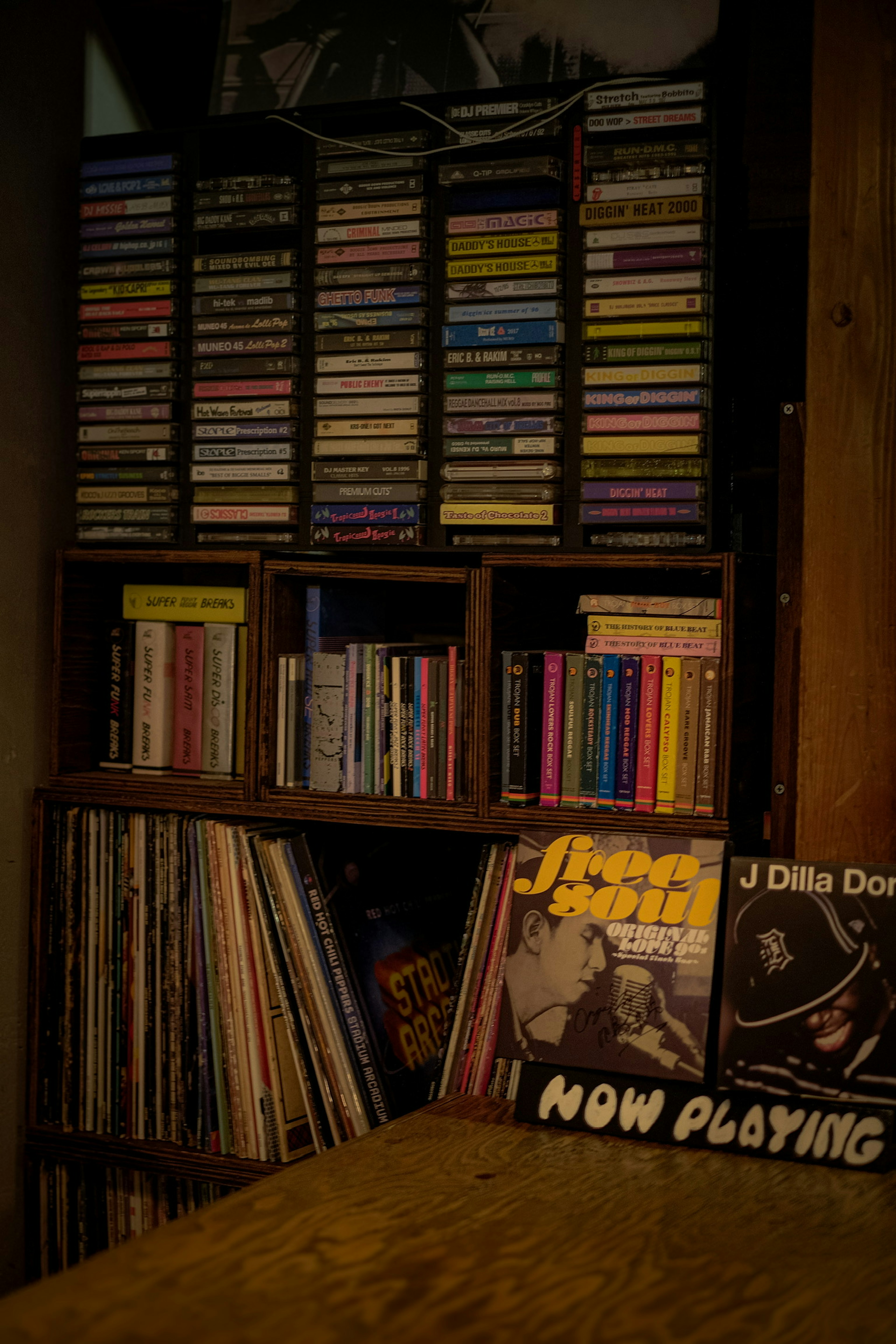 A music collection shelf filled with cassette tapes and vinyl records