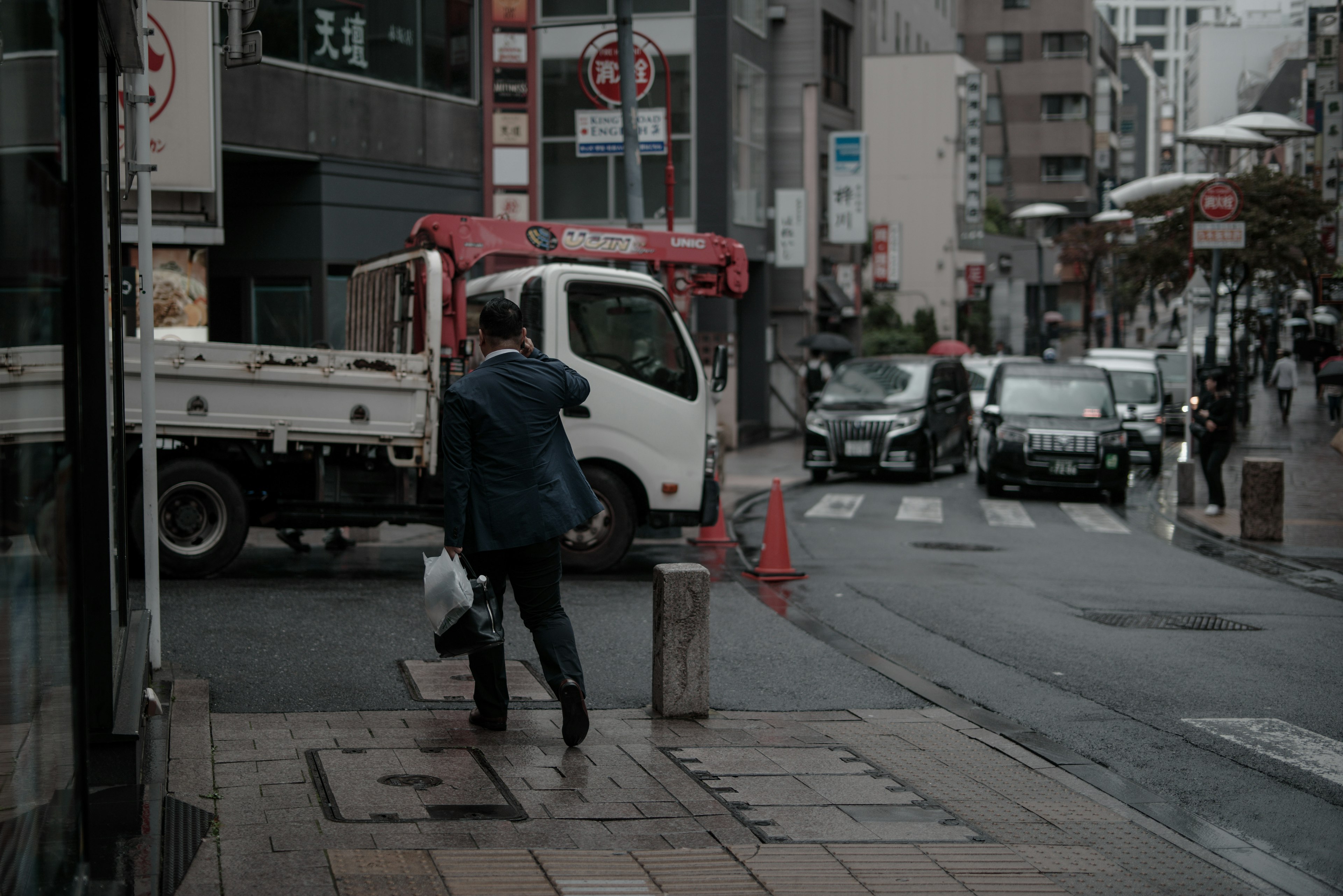 Businessman walking on urban street corner with truck