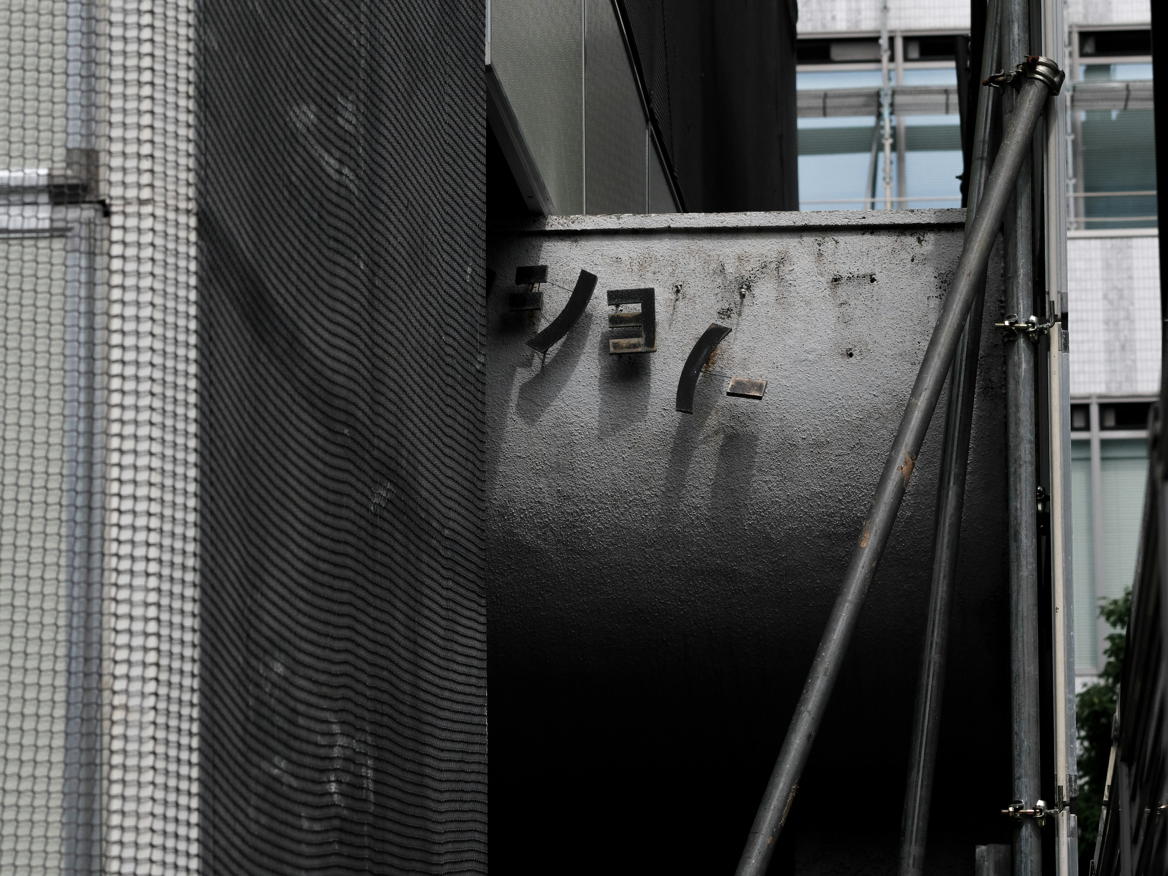 Tube métallique fixé à un mur de bâtiment avec échafaudage en acier