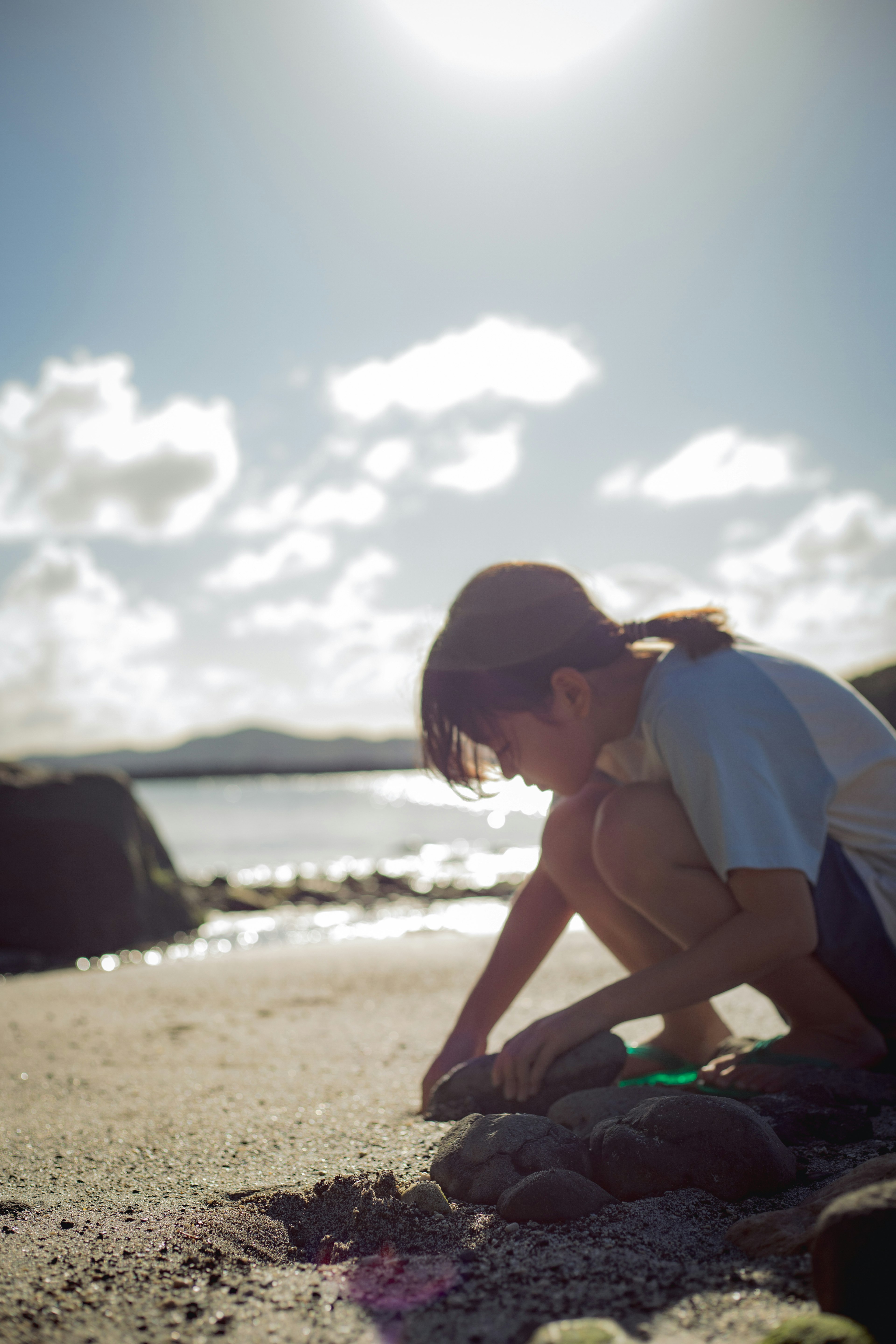 Silhouette eines Jungen, der sich am Strand auf den Sand konzentriert