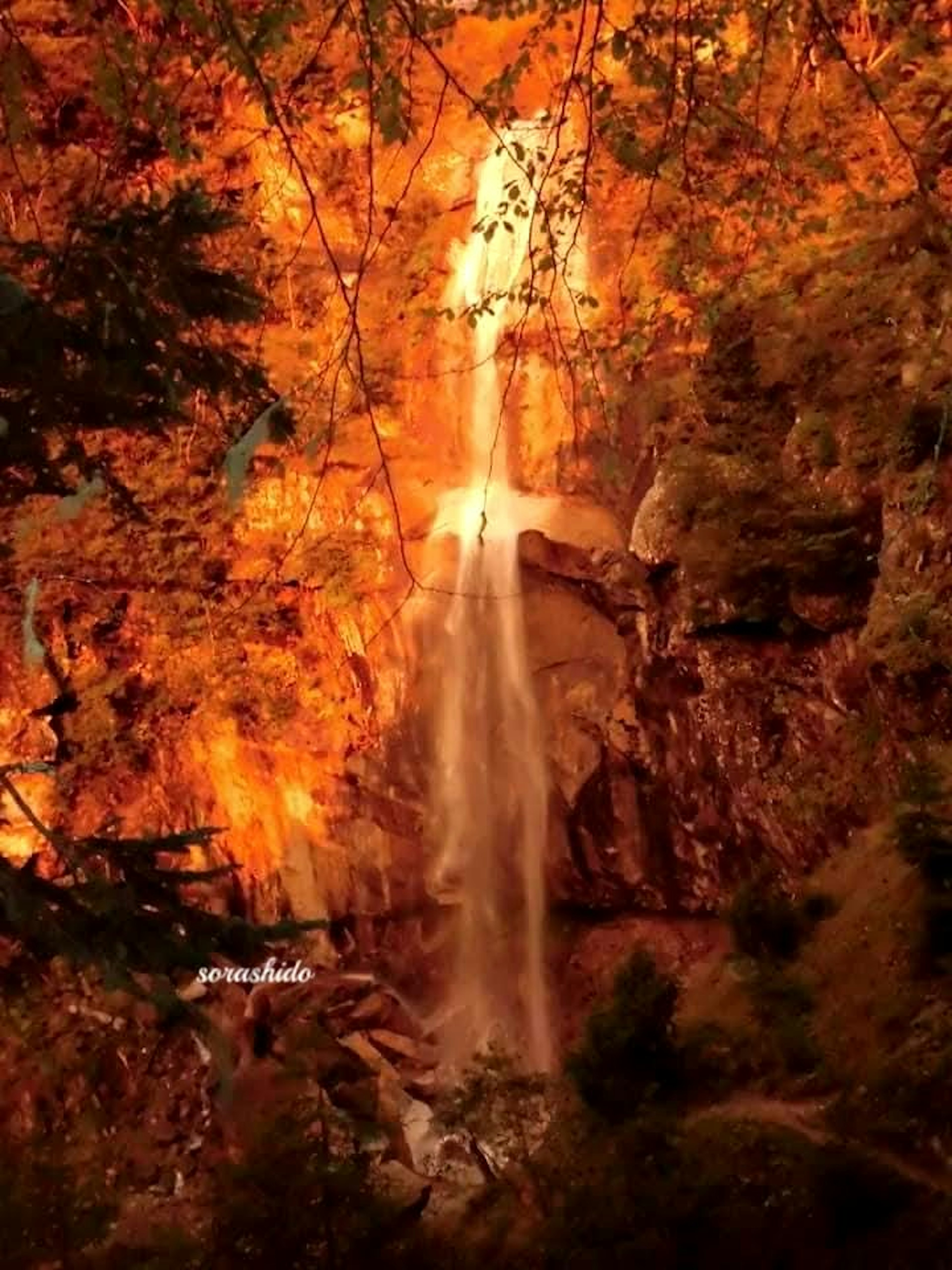 Una impresionante cascada rodeada de vibrante follaje otoñal