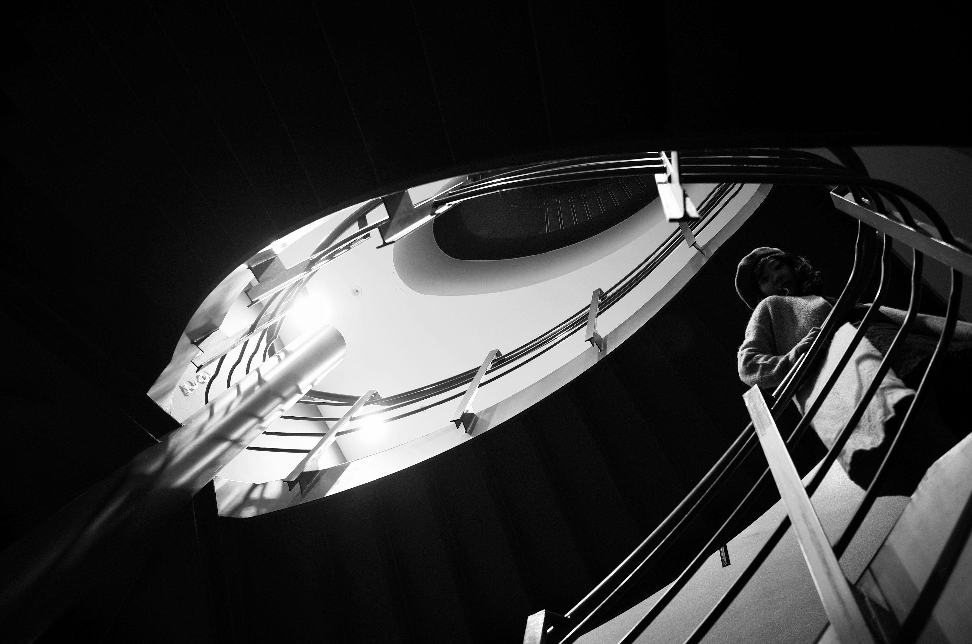 Modern staircase viewed from above featuring sleek handrails and reflections of light