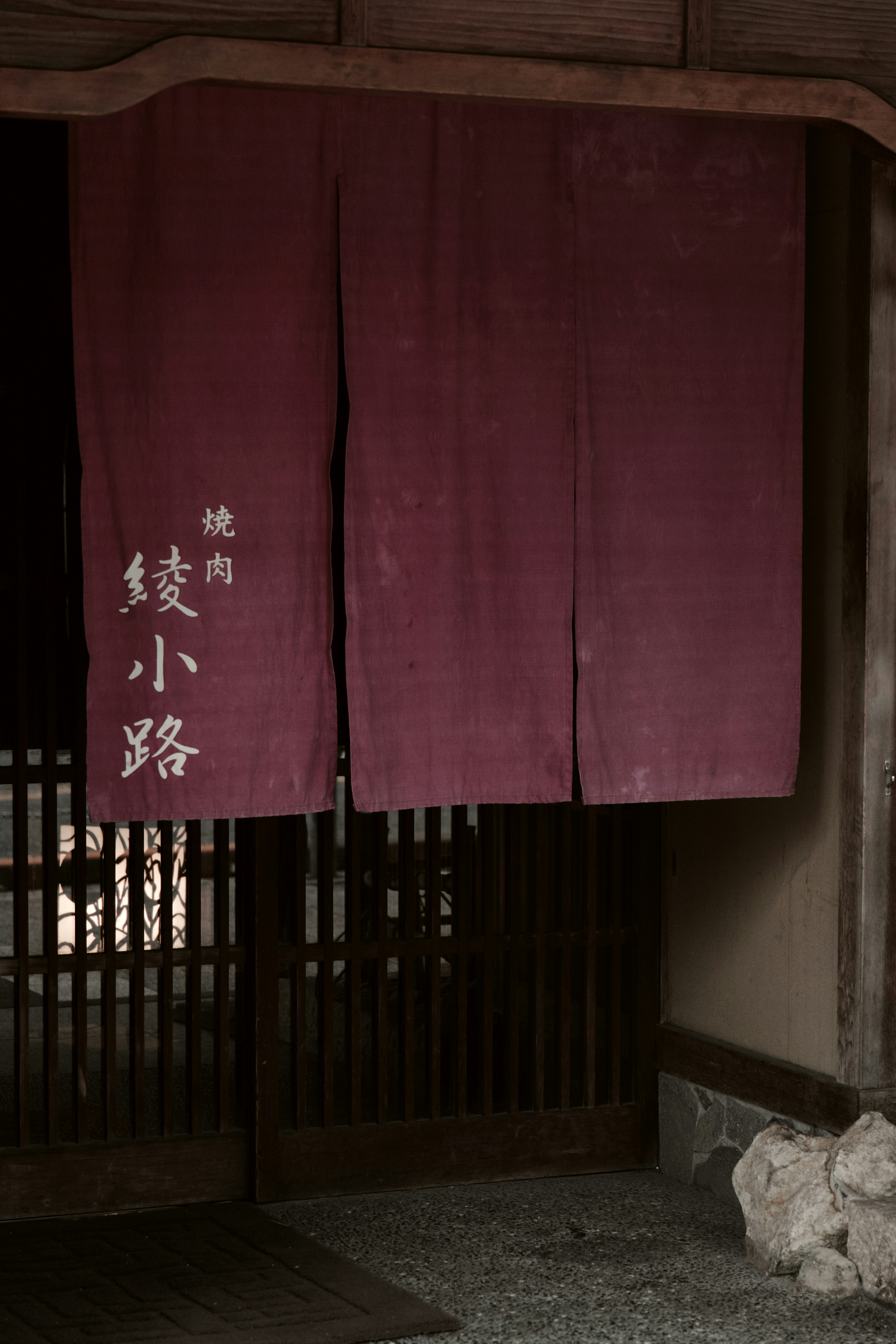 Image of a traditional Japanese entrance with a deep purple noren curtain