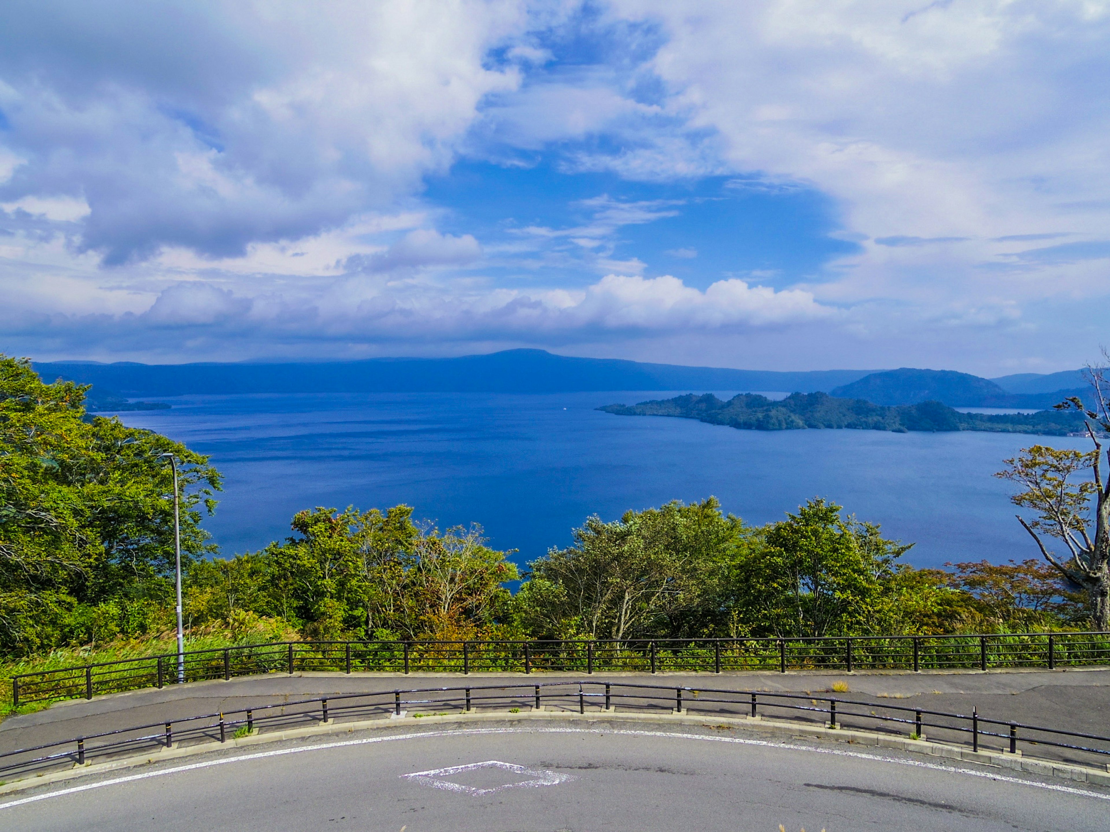 Malerei Aussicht auf einen See und blauen Himmel Grüne Bäume und entfernte Inseln