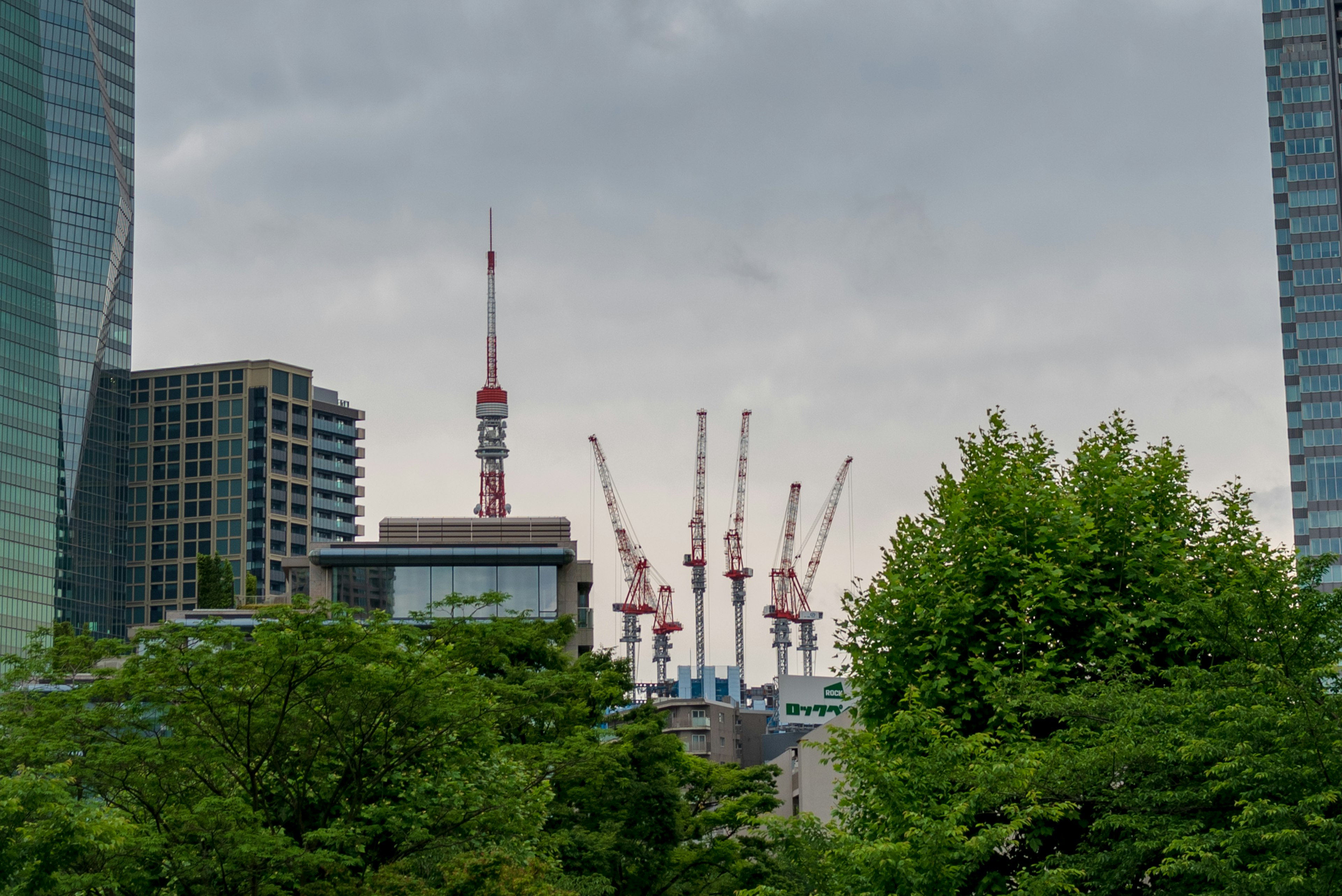 Vue de la tour de Tokyo et des grues de construction entre des gratte-ciels