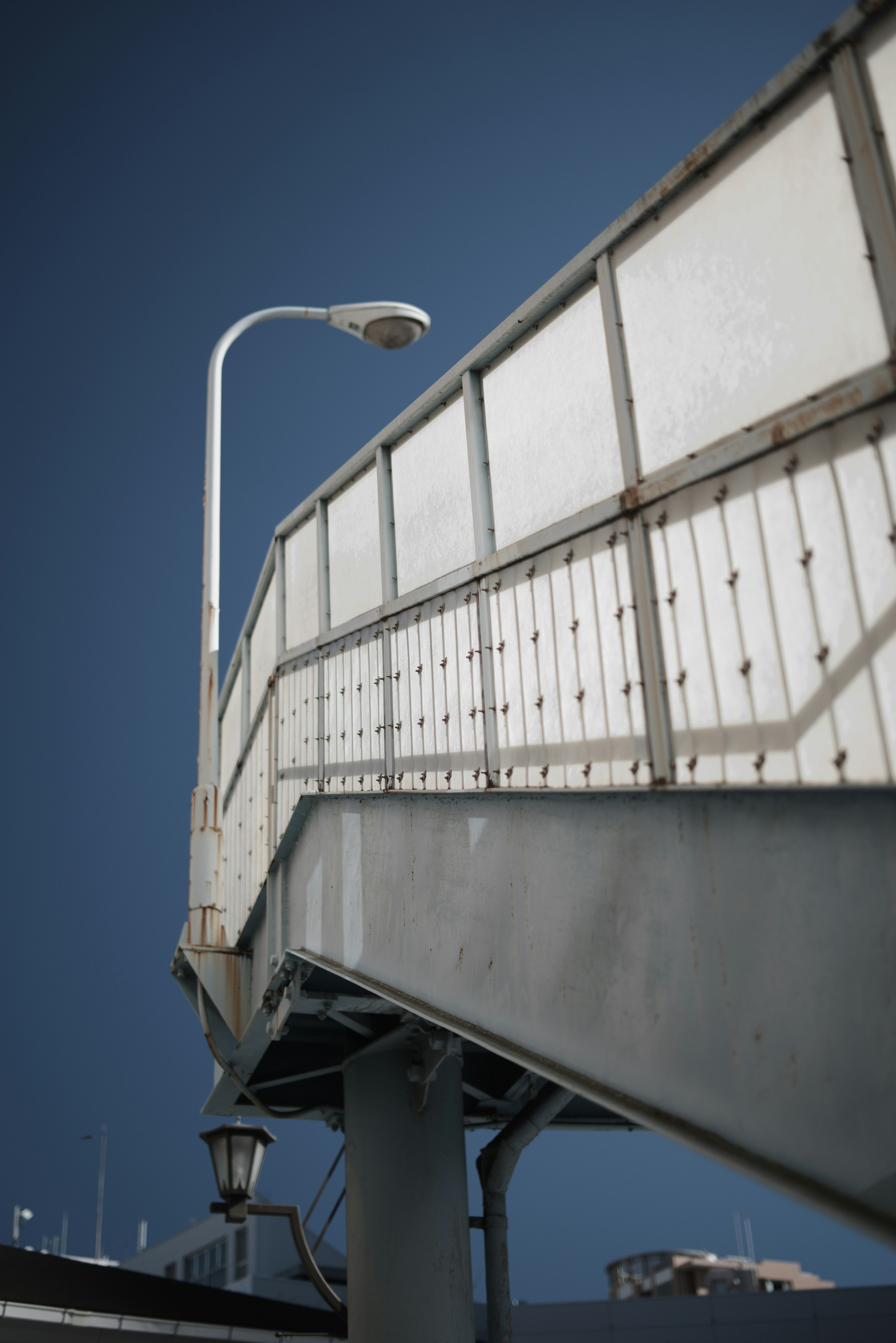 Diagonal view of an elevated walkway with a bright street lamp