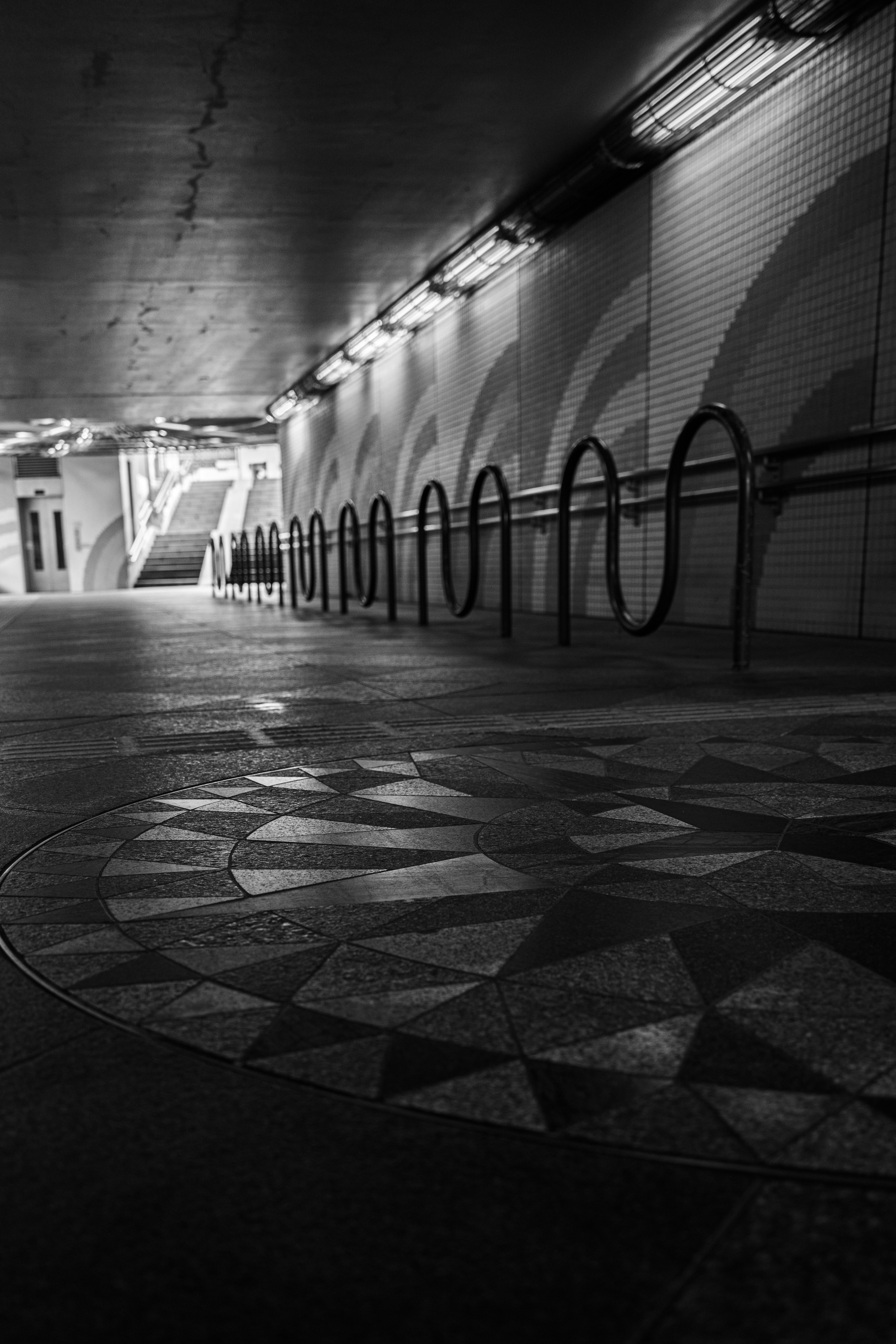 Vista de un túnel de metro con patrones de mosaico intrincados y aparcabicis