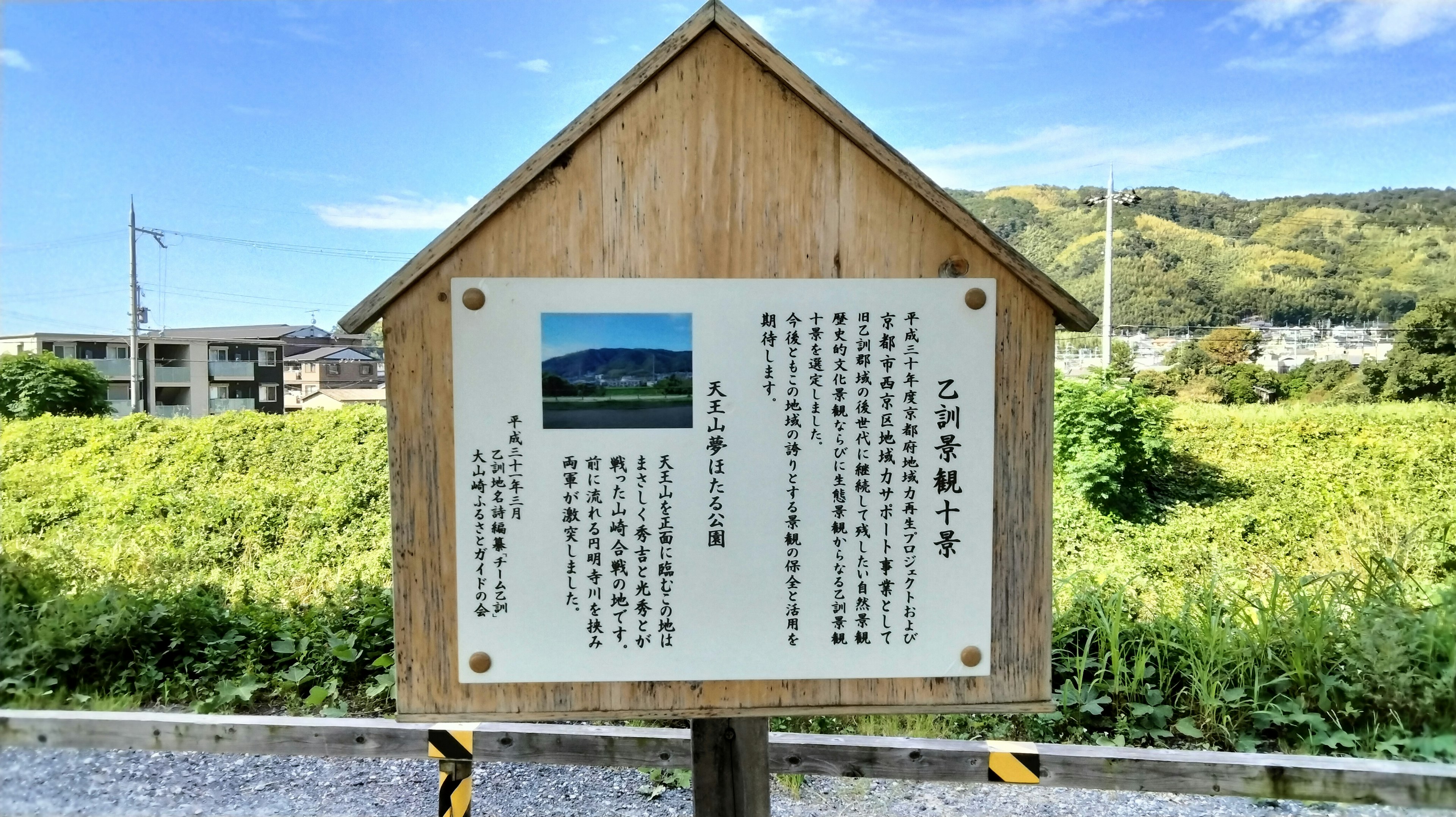 Cartel de madera que muestra una foto del paisaje y texto descriptivo