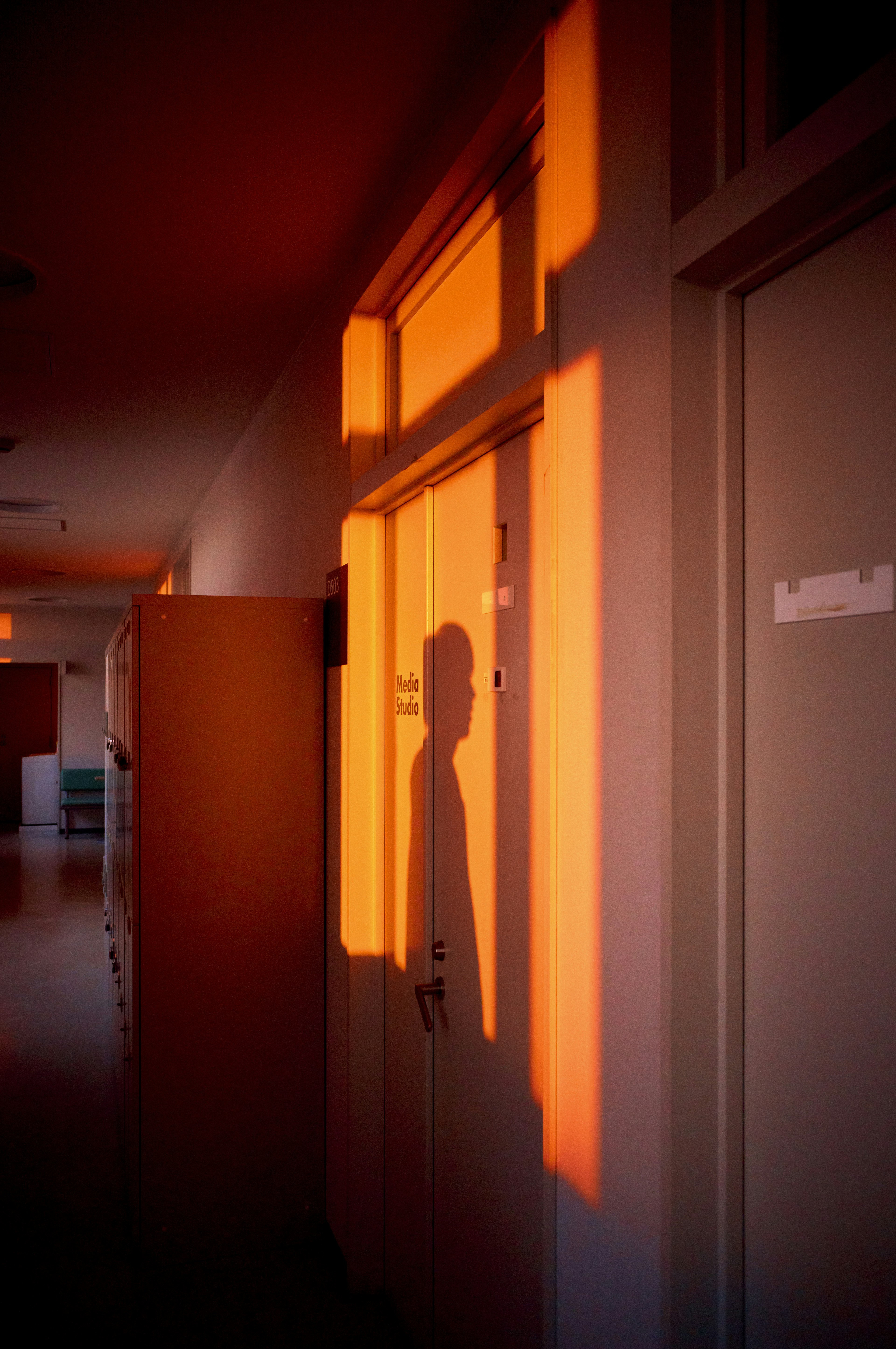 Silhouette d'une personne projetée par la lumière du coucher de soleil dans un couloir